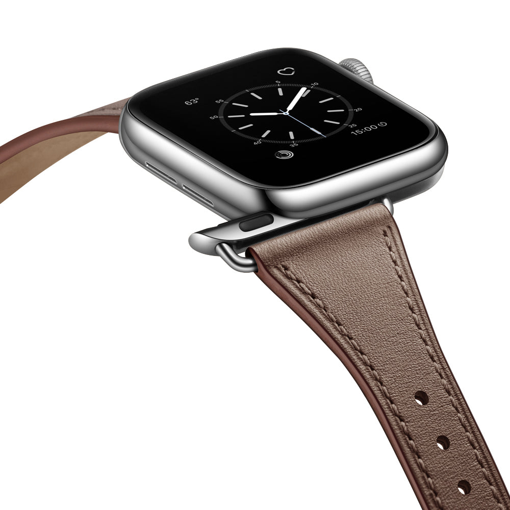 Eine Nahaufnahme des Apple Watch Lederarmbands „Napoli“ zeigt eine minimalistische Smartwatch mit quadratischem schwarzem Display, silbernem Gehäuse und braunem Echtlederarmband. Das analoge Zifferblatt ist auf dem Display sichtbar.