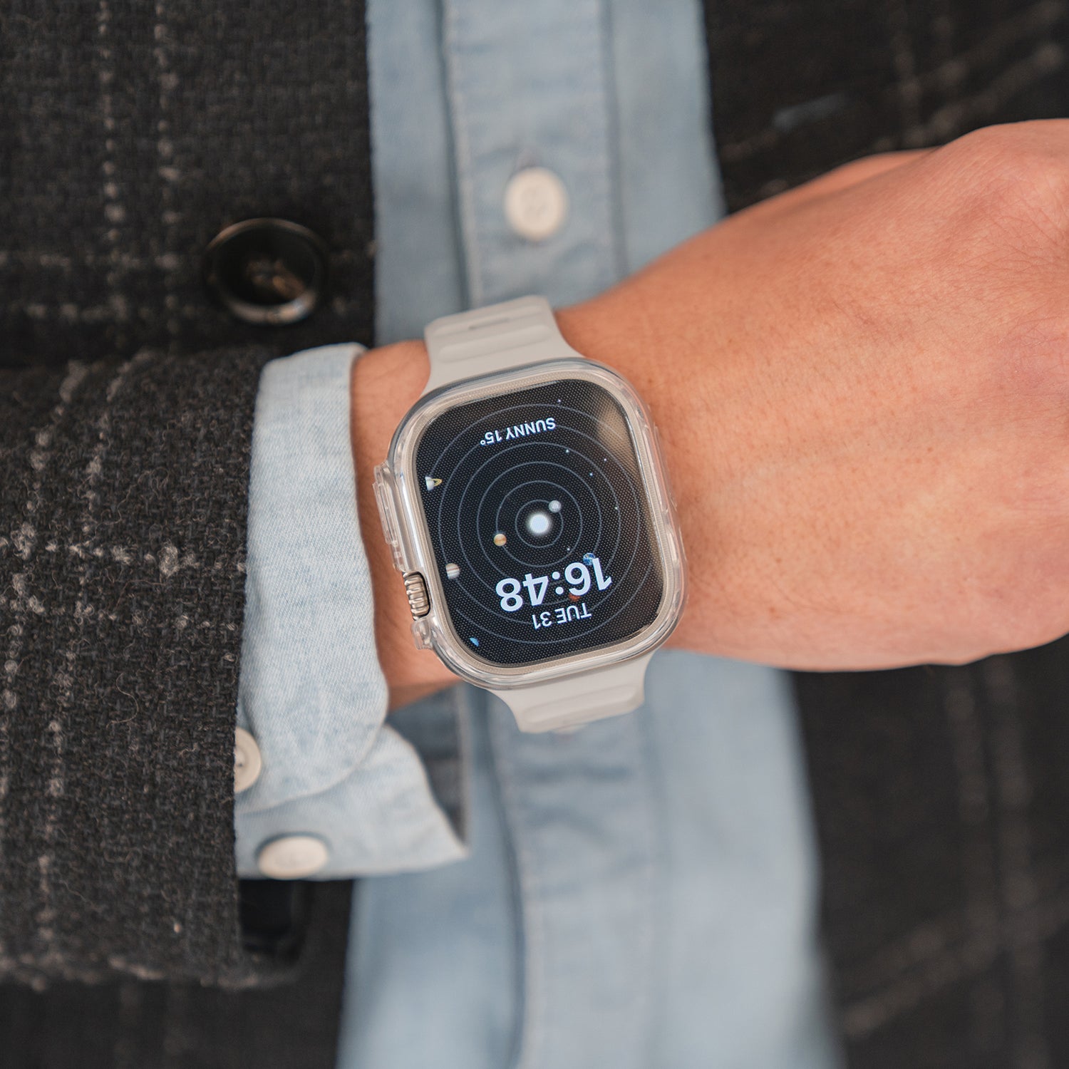 Eine Person, die eine Smartwatch mit grauem Band und ein blaues Hemd trägt (16:48) zeigt, protzt mit ihrem arktis.de ArktisPRO Invisible Air Case für Apple Watch Ultra für eleganten Stil und 360°-Schutz.