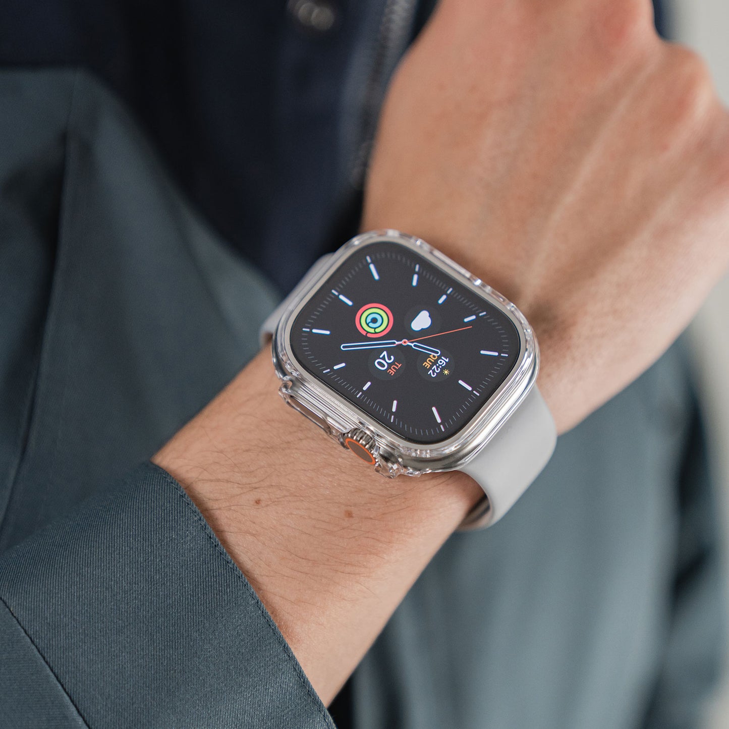 Eine Person trägt eine Apple Watch Ultra 49 mm mit grauem Armband und Fitness-Tracking-Display, geschützt durch den ArktisPRO CRYZTAL BUMPER aus strapazierfähigem Polycarbonat.