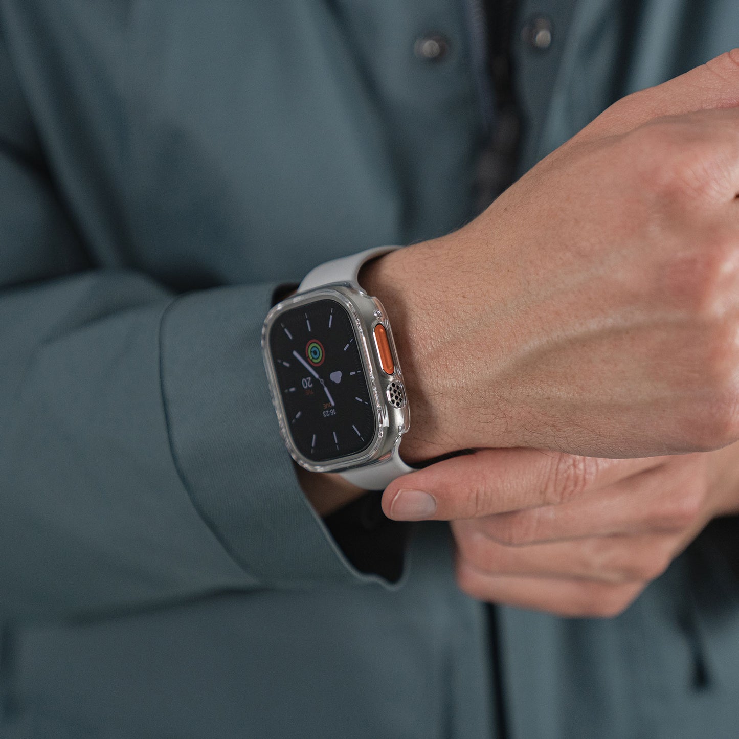 Eine Person passt ihre Apple Watch Ultra 49 mm, die mit dem ArktisPRO CRYZTAL BUMPER von ArktisPRO geschützt ist, an, während sie sie am Handgelenk trägt.