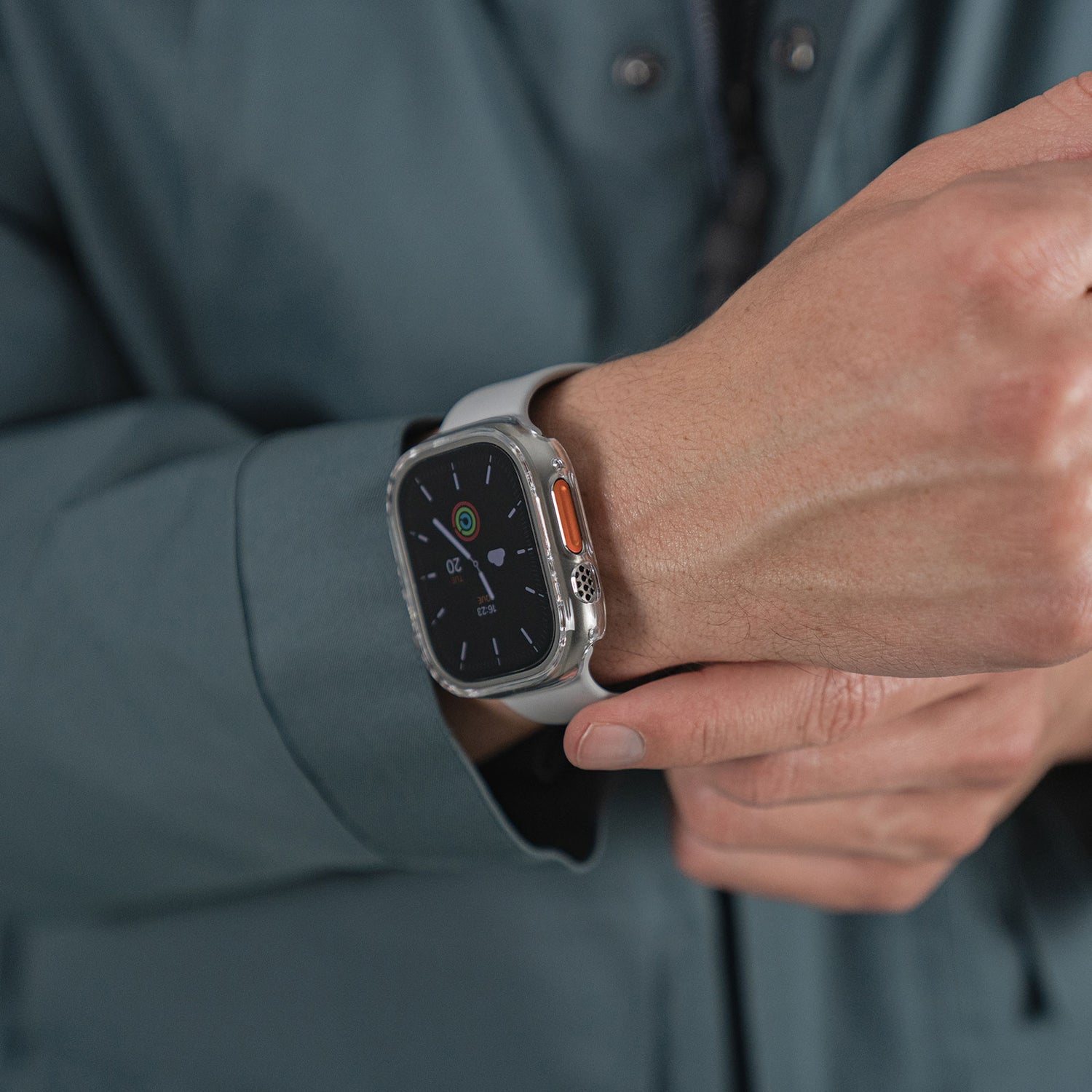 Eine Person passt ihre Apple Watch Ultra 49 mm, die mit dem ArktisPRO CRYZTAL BUMPER von ArktisPRO geschützt ist, an, während sie sie am Handgelenk trägt.