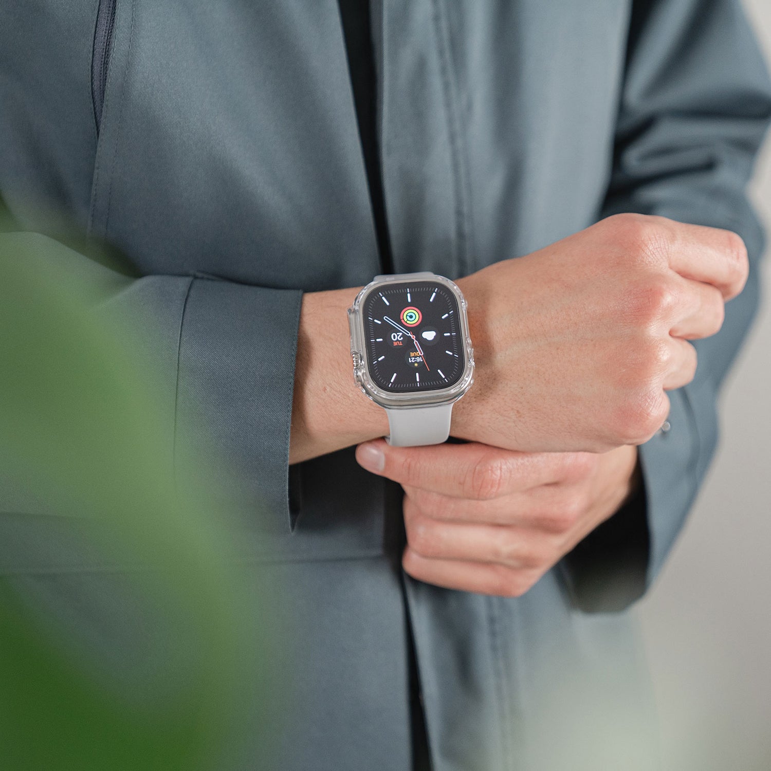 Person trägt eine Apple Watch Ultra 49 mm mit Digitalanzeige, geschützt durch den ArktisPRO CRYZTAL BUMPER, kombiniert mit einer grauen Jacke.