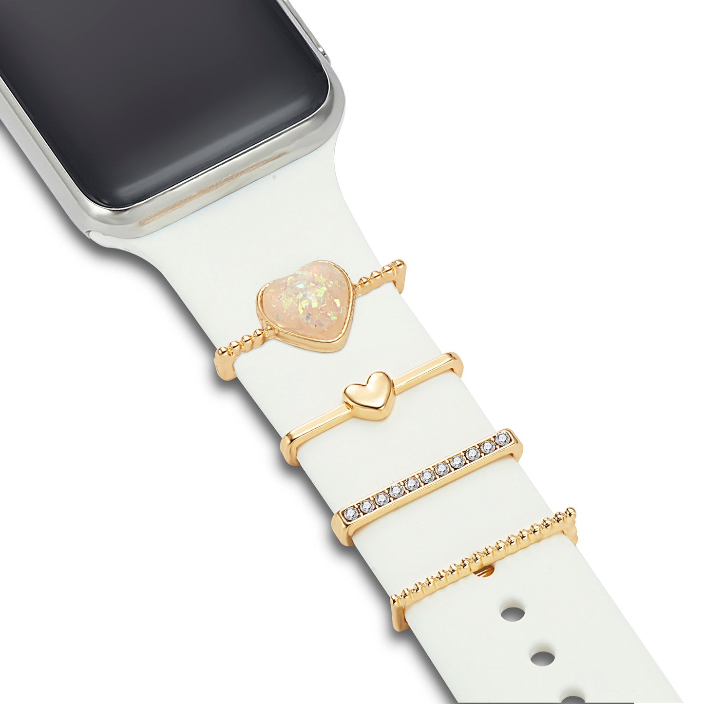 Ein weißes Arktisband-Smartwatch-Armband, verziert mit vier Arktisband-Apple-Watch-Armband-Charms – herzförmiger Edelstein, goldenes Herz, Reihe klarer Steine und goldener Balken – kombiniert mit einem silbernen Zifferblatt für einen individuellen gestaltbar-Stil.