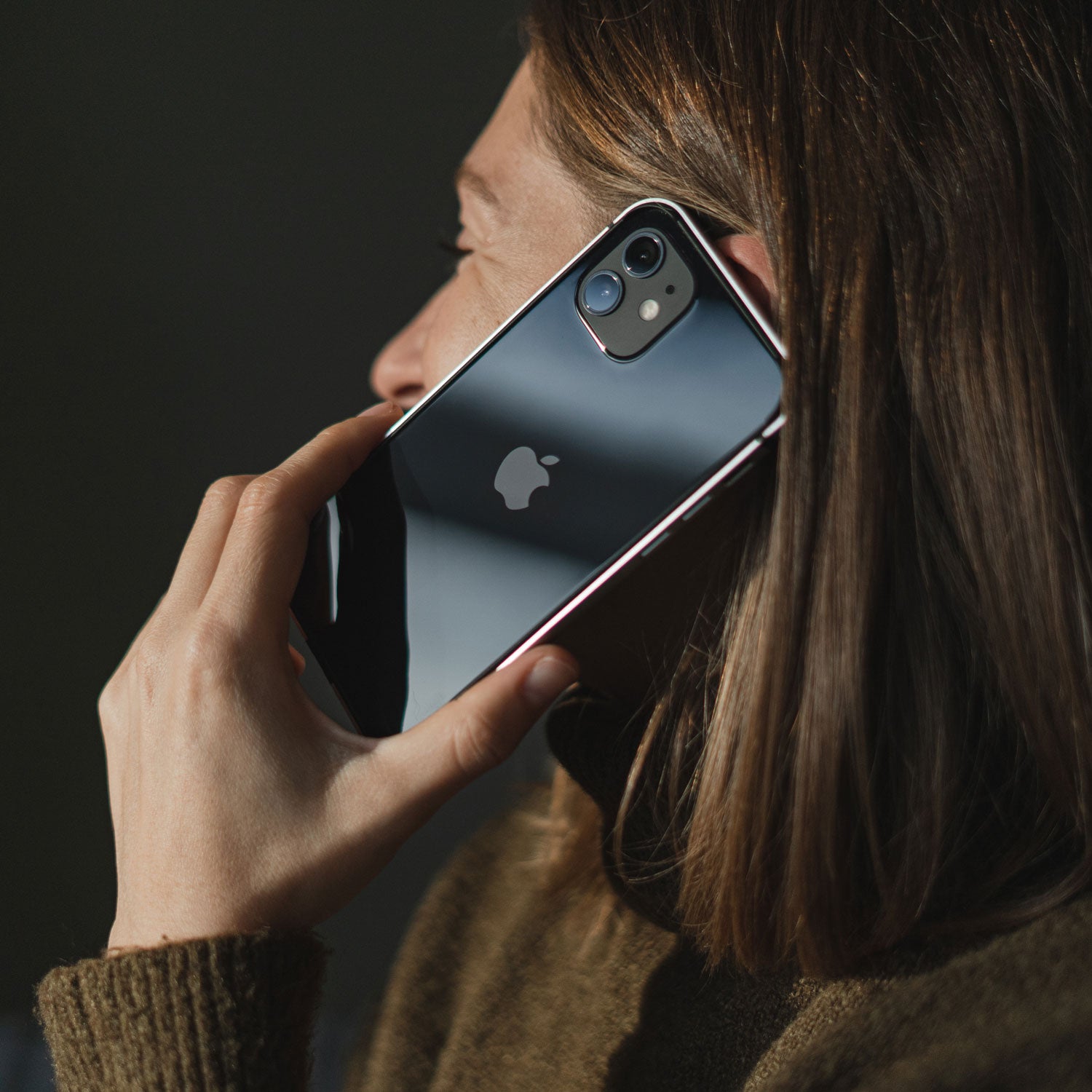 Person hält einen Aviato AirZERO Alu Bumper für das iPhone 12 mini von Aviato von arktis.de ans Ohr und telefoniert.