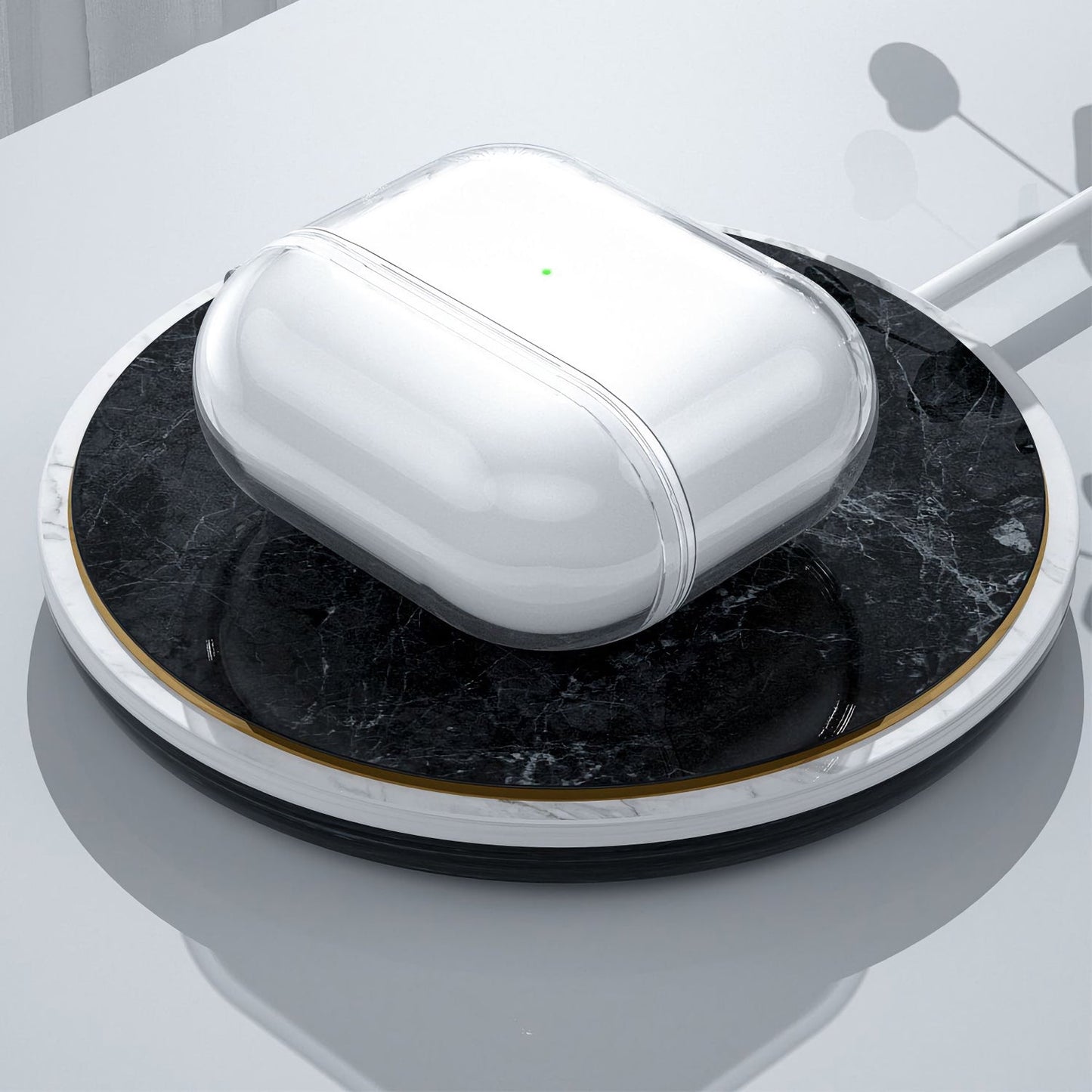 Arktis AirPods Pro 3 Invisible Air Case kabellose Ohrhörer von arktis, die auf einem kabellosen Pad aus schwarzem Marmor auf einer glänzenden Oberfläche geladen werden.