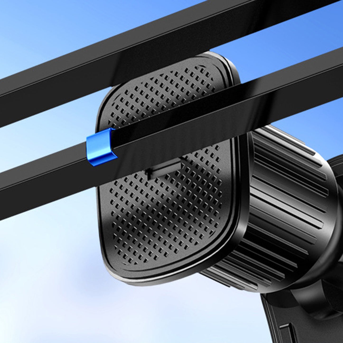 Eine Nahaufnahme der ArktisPRO MagSafe Autohalterung von ArktisPRO, ein schwarz strukturiertes Gerät, das mit einem blauen Clip an zwei parallelen schwarzen Balken befestigt ist, vor einem blauen Himmelshintergrund.