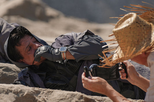 Rainer Wolf filmt mit dem iPhone einen Mann der im Sand liegt