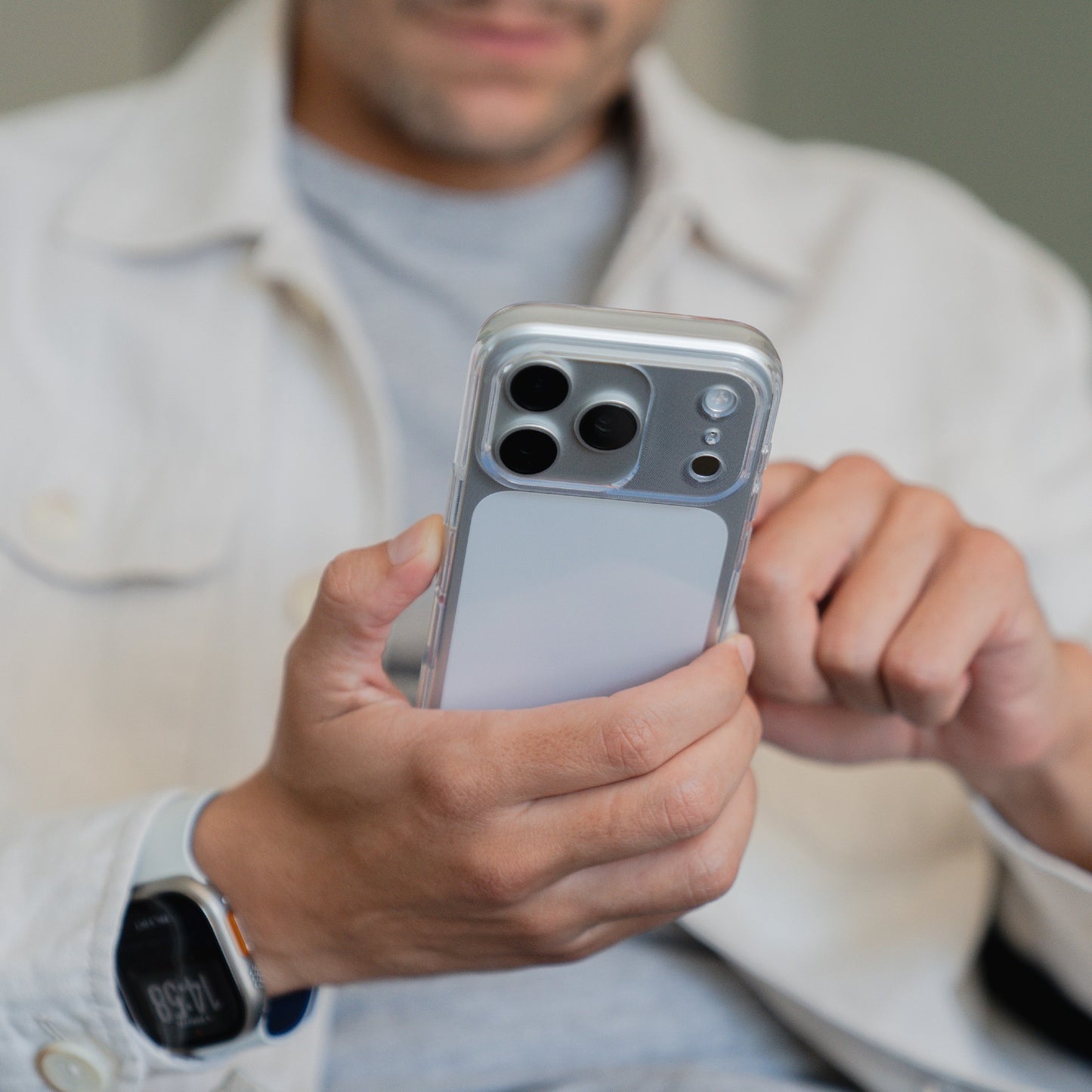 Eine Person, die eine Smartwatch trägt, benutzt ein Smartphone mit dem arktis iPhone 17 Pro Max Invisible Case. Die arktis Hülle bietet sowohl Stil als auch Schutz für den täglichen Gebrauch und lässt das Design des Telefons durchscheinen.