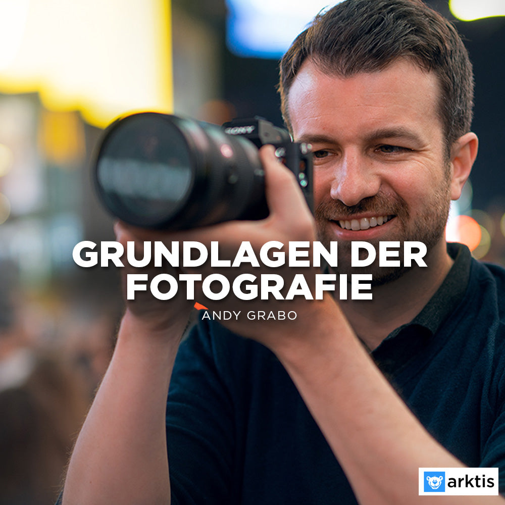 Ein Mann lächelt, während er eine Kamera hält, um ein Foto zu machen. Der deutsche Text lautet „Grundlagen der Fotografie“ von Andy Grabo. Ideal für Einsteigerfotografie, mit dem Arktis-Logo in der unteren rechten Ecke.