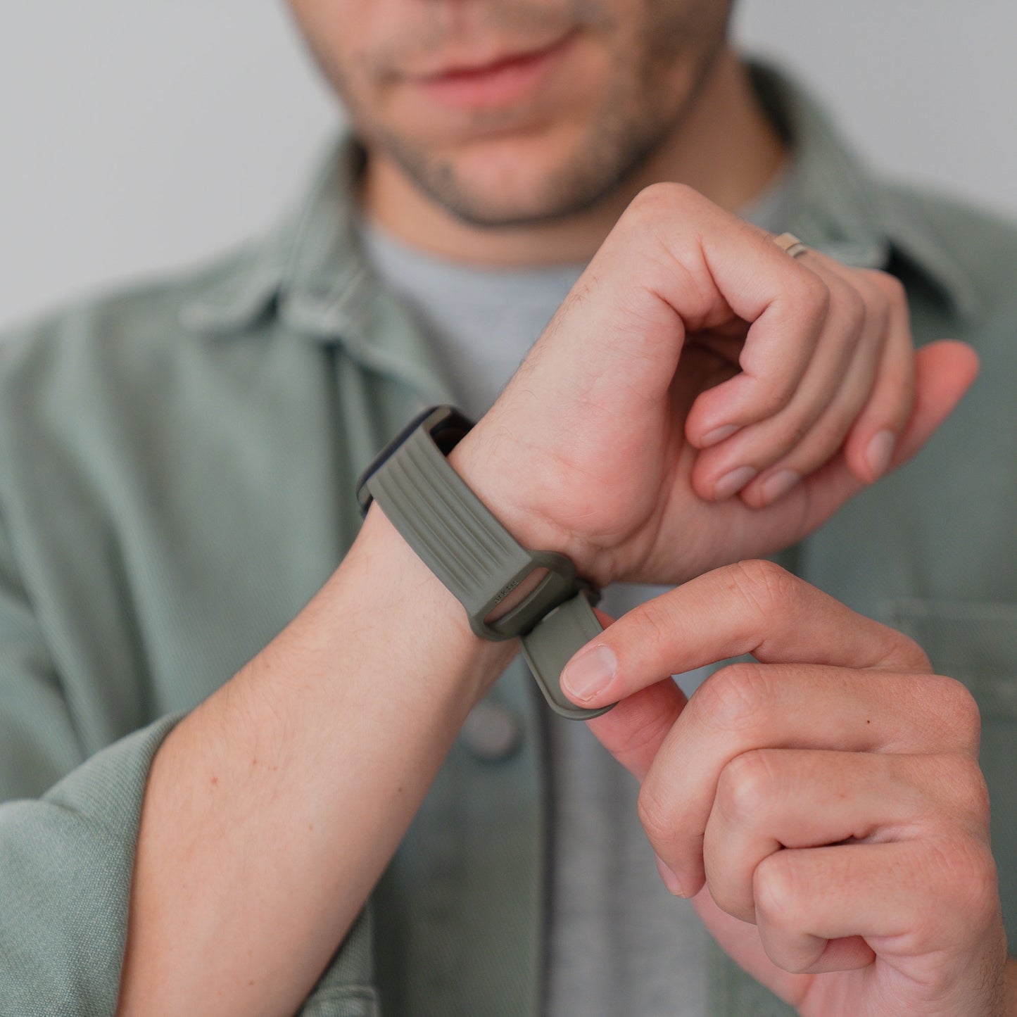 Eine Person, die ein grünes Apple Watch Armband "Skandi" von arktisband an ihrem Handgelenk befestigt und ein passendes grünes Hemd trägt.