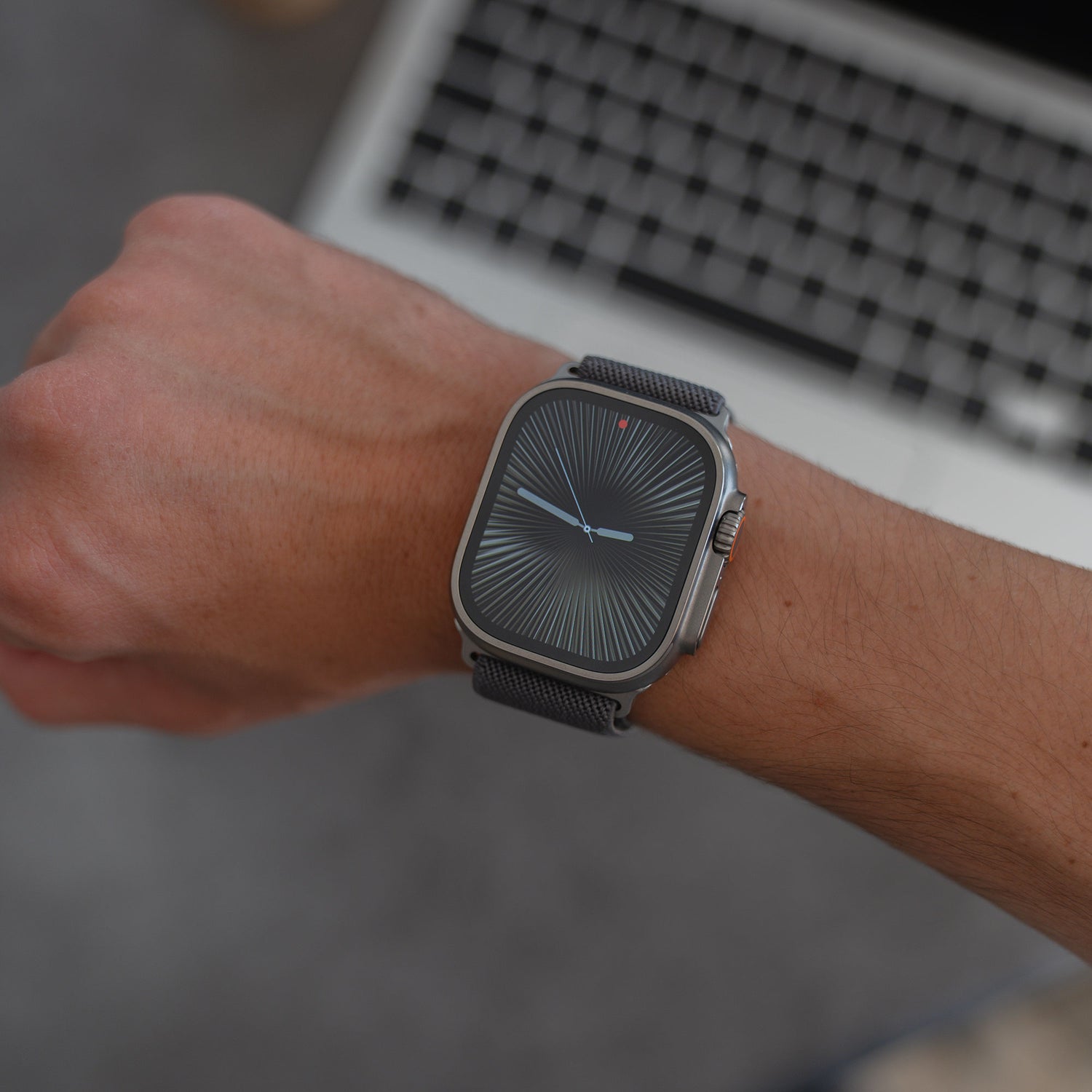 Ein arktisband Apple Watch Nylonarmband "FlexOne" mit gemustertem Zifferblatt sitzt stilvoll am Handgelenk, sein strapazierfähiges Nylonband ergänzt die Kulisse einer Laptop-Tastatur.