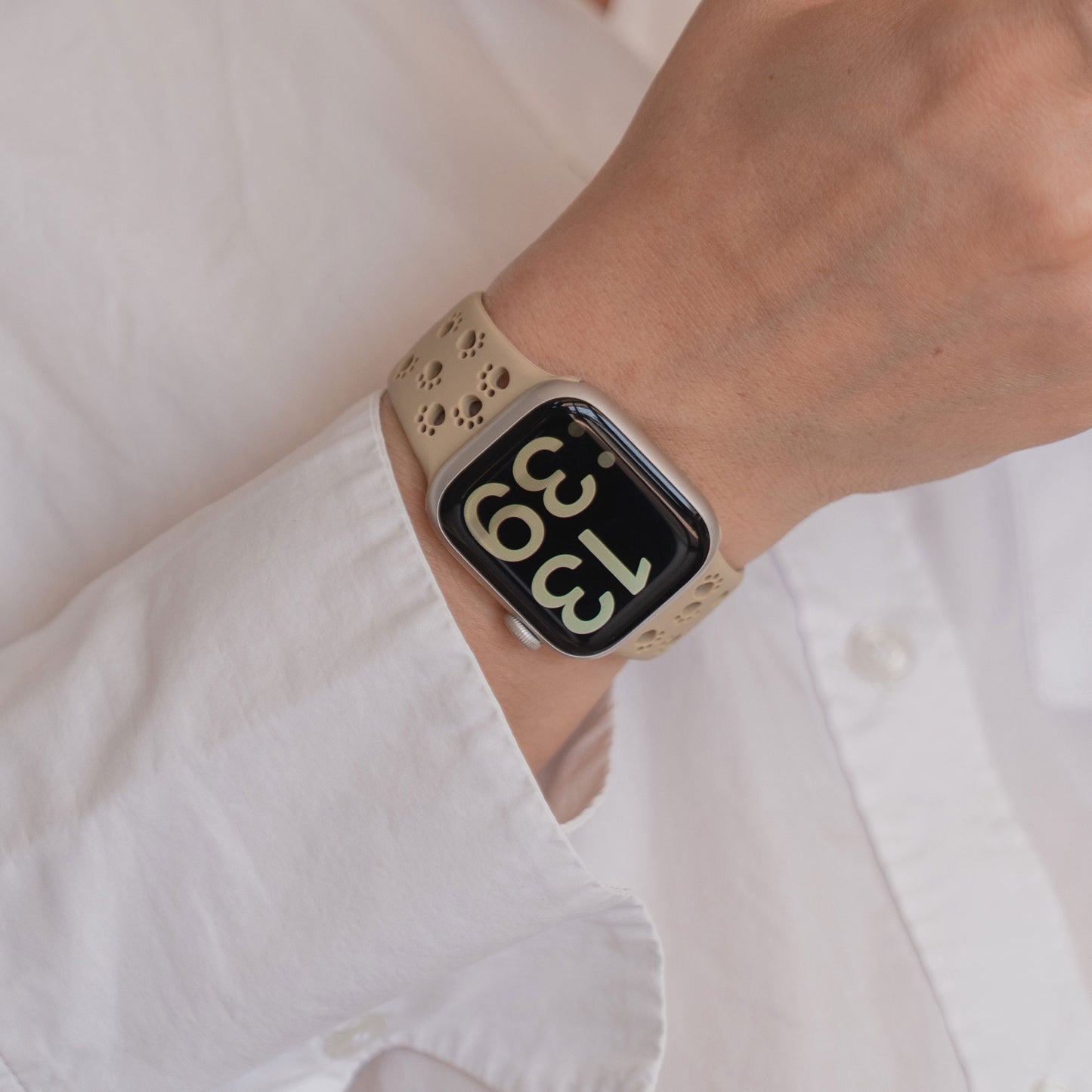 Eine Person, die ein Arktisband Apple Watch Silikonarmband "Paw" mit einer digitalen Anzeige trägt, bekleidet mit einem weißen Hemd.