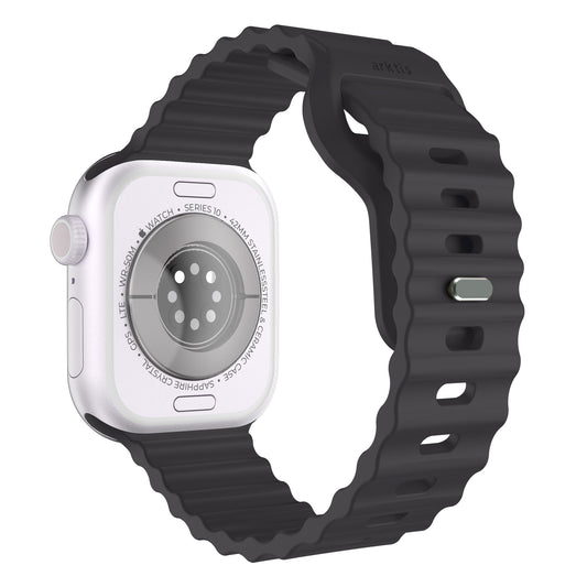 Nahaufnahme der Rückseite einer weißen Smartwatch mit schwarzem, wellenförmigem Silikonarmband. Die Uhrensensoren, der eingravierte Text und das geprägte Arktisband-Logo sind auf dem sportlichen Arktisband Apple Watch Sportarmband „Motion“ deutlich zu erkennen.