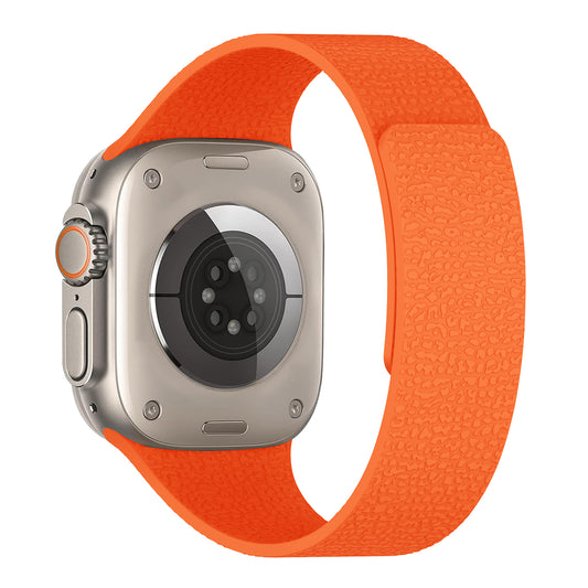 Das Arktisband Apple Watch magnetisches Silikonarmband "Flexy" zeigt sich in Orange mit einer strukturierten Optik, die den hinteren Sensorbereich und den sicheren Magnetverschluss hervorhebt.