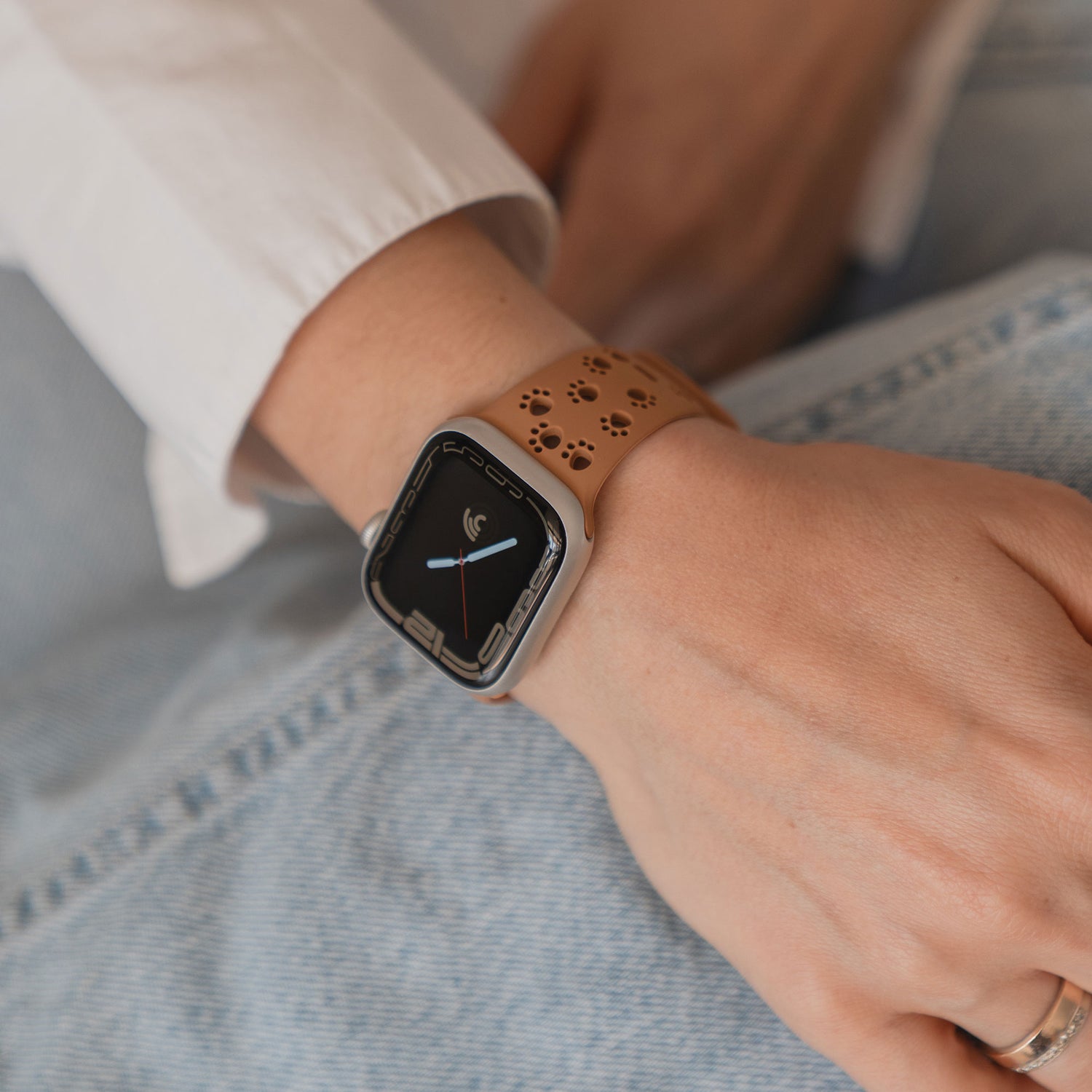 Eine Hand trägt das arktisband Apple Watch Silikonarmband "Paw", ein hellbraunes Silikonarmband von arktisband mit einem charmanten Pfotendesign.