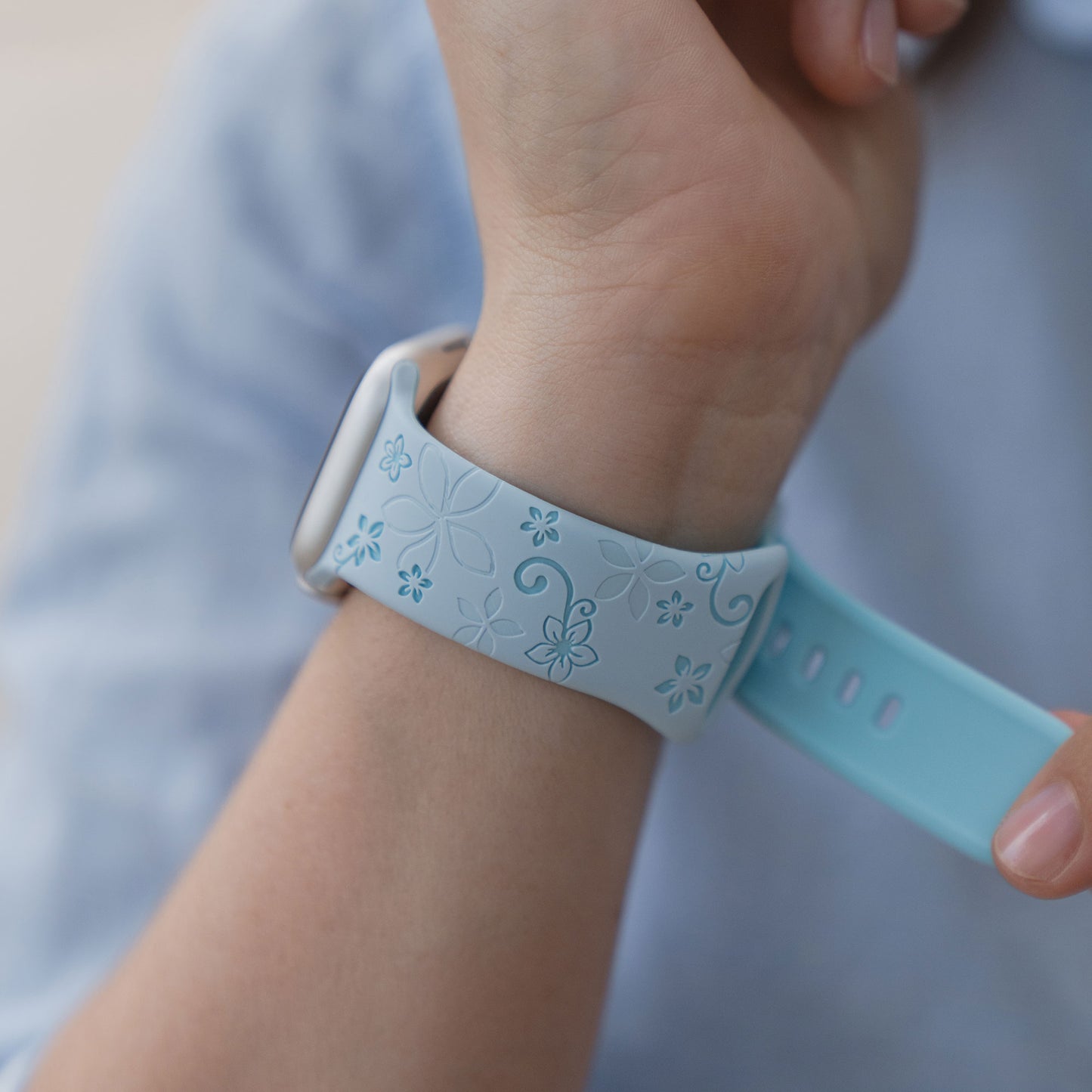 Eine Person trägt das arktisband Apple Watch Silikonarmband "Bloom" mit einem floralen Muster am Handgelenk, kompatibel mit der Apple Watch.