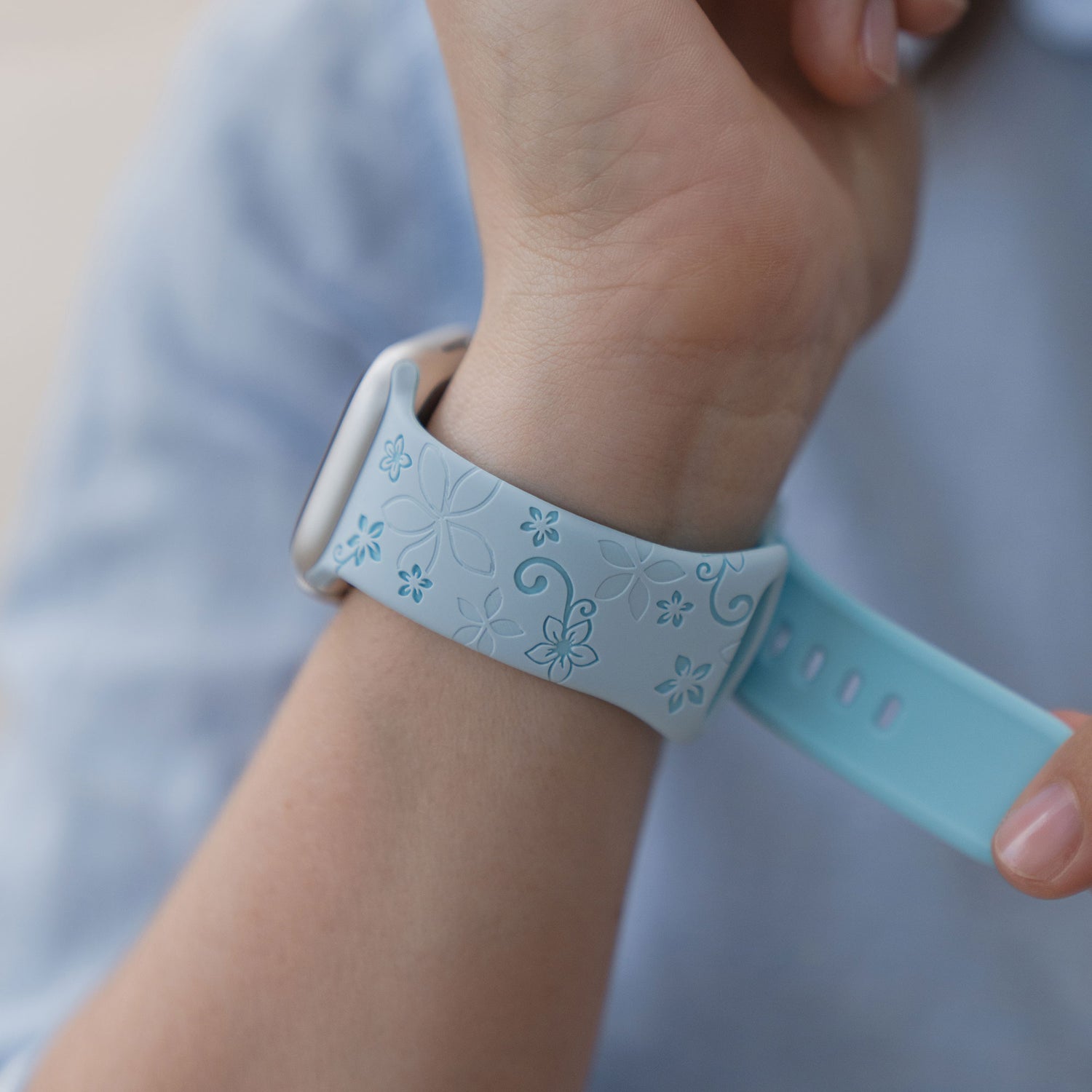 Eine Person trägt das arktisband Apple Watch Silikonarmband "Bloom" mit einem floralen Muster am Handgelenk, kompatibel mit der Apple Watch.