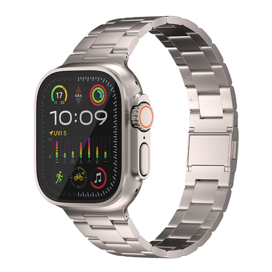 Das Arktisband Apple Watch Titan Gliederarmband „Prime“ verfügt über ein silbernes Gehäuse, einen MagneticClick-Verschluss, eine orange akzentuierte digitale Krone und ein abgerundetes rechteckiges Display, das die Uhrzeit 10:09 sowie Fitness- und App-Symbole anzeigt.