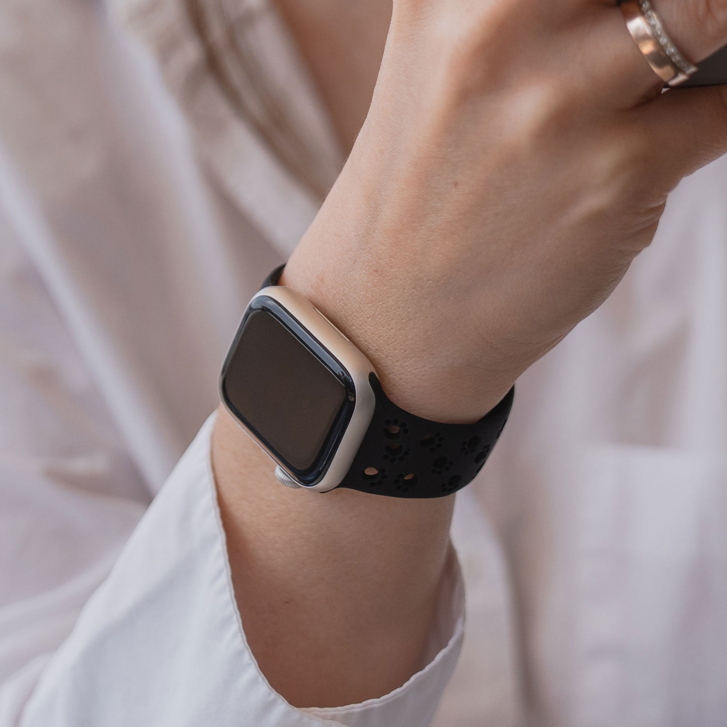 Eine Person mit einem arktisband Apple Watch Silikonarmband "Paw" von arktisband in schwarz, mit weißem Hemd und einer Tasse in der Hand.
