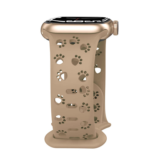Das arktisband Apple Watch Silikonarmband "Paw" von arktisband, in Beige mit ausgeschnittenen Pfotenmotiven, wird auf einer Apple Watch vor weißem Hintergrund dargestellt.