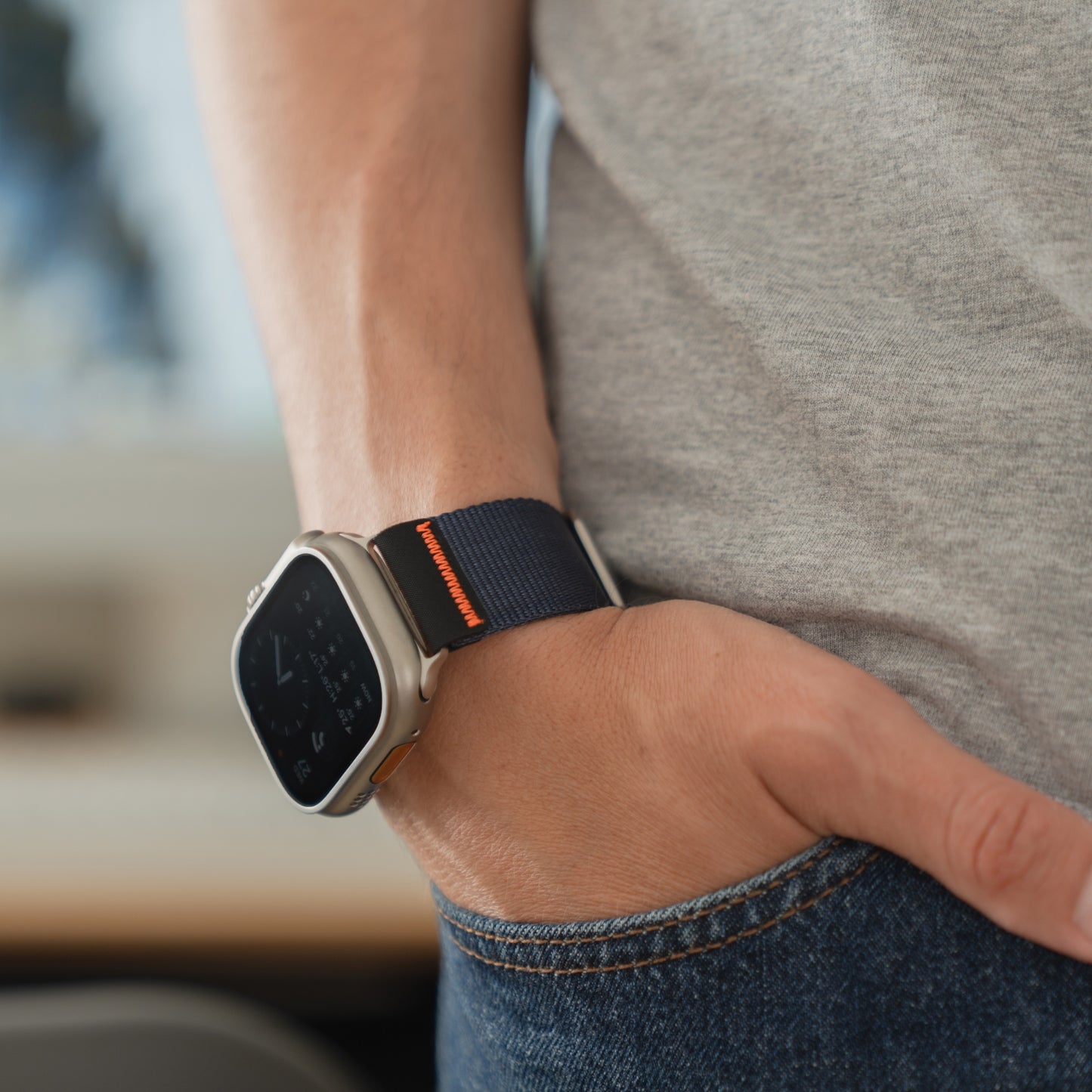 Jemand trägt ein arktisband Apple Watch Armband "Terra" von arktisband - ein extra breites 24-mm-Nylonband - an seiner Apple Watch Ultra, während die Hand in einer Jeanstasche ruht.