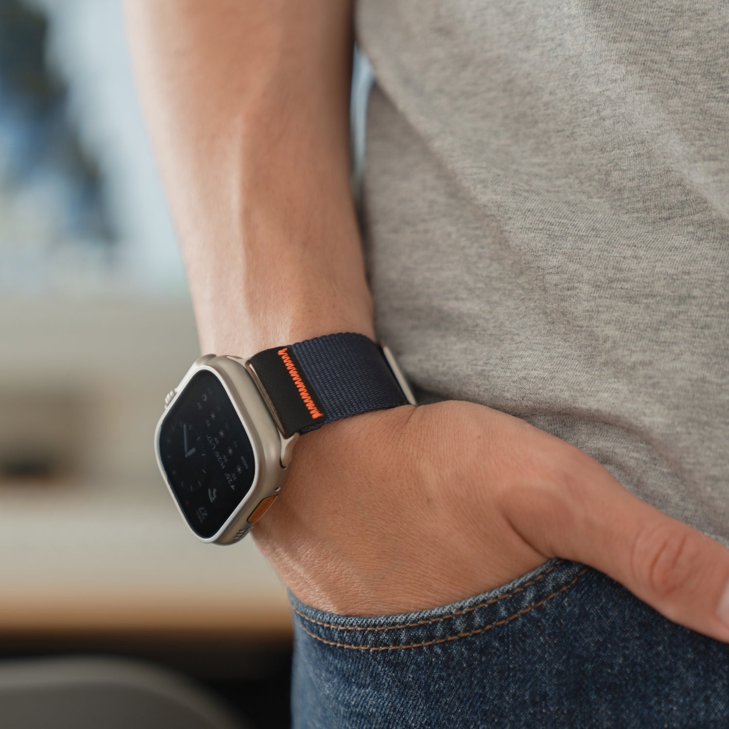 Jemand trägt ein arktisband Apple Watch Armband "Terra" von arktisband - ein extra breites 24-mm-Nylonband - an seiner Apple Watch Ultra, während die Hand in einer Jeanstasche ruht.