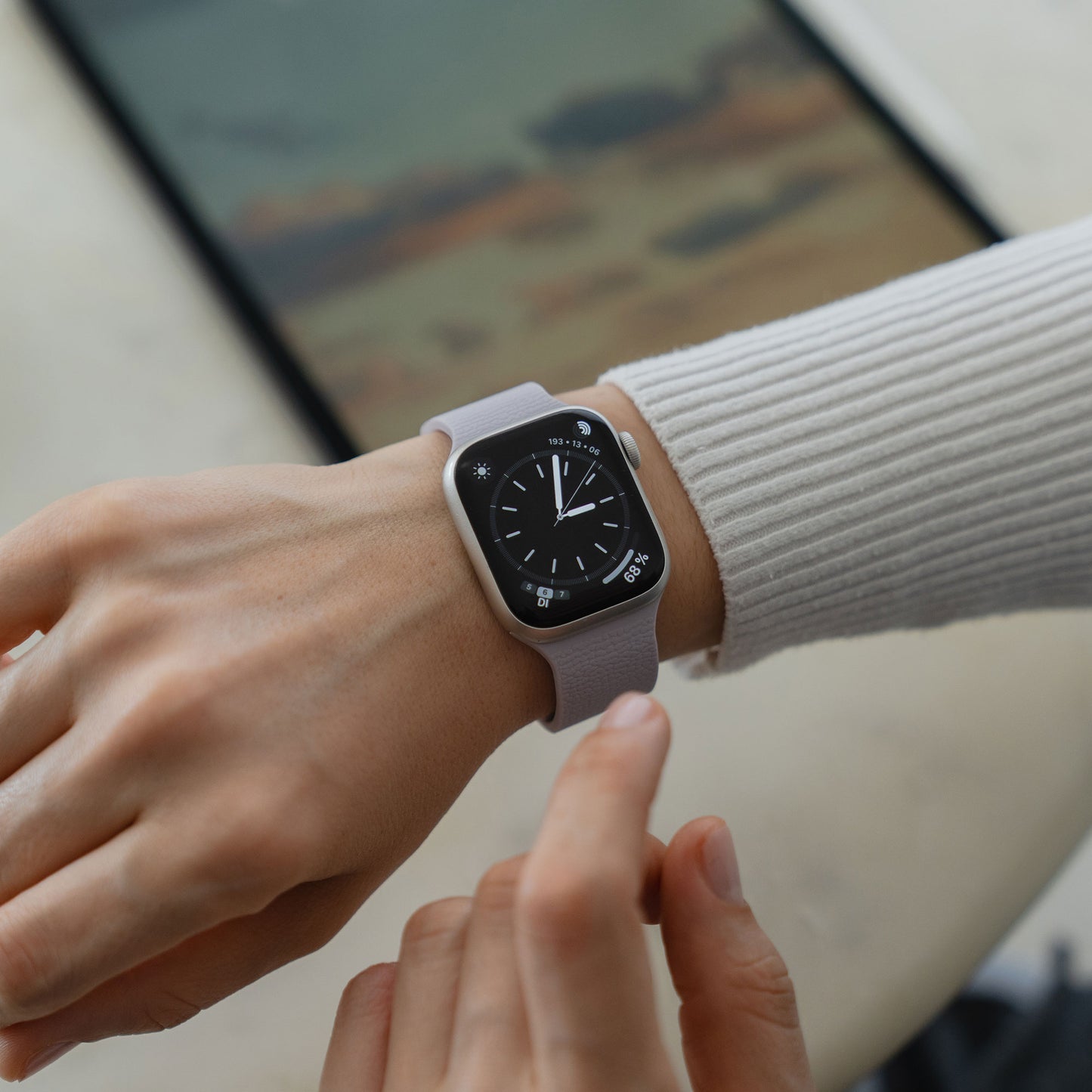 Eine Person, die eine Apple Watch mit dem magnetischen Silikonarmband "Flexy" in Grau trägt, überprüft die Zeit an ihrem Handgelenk.