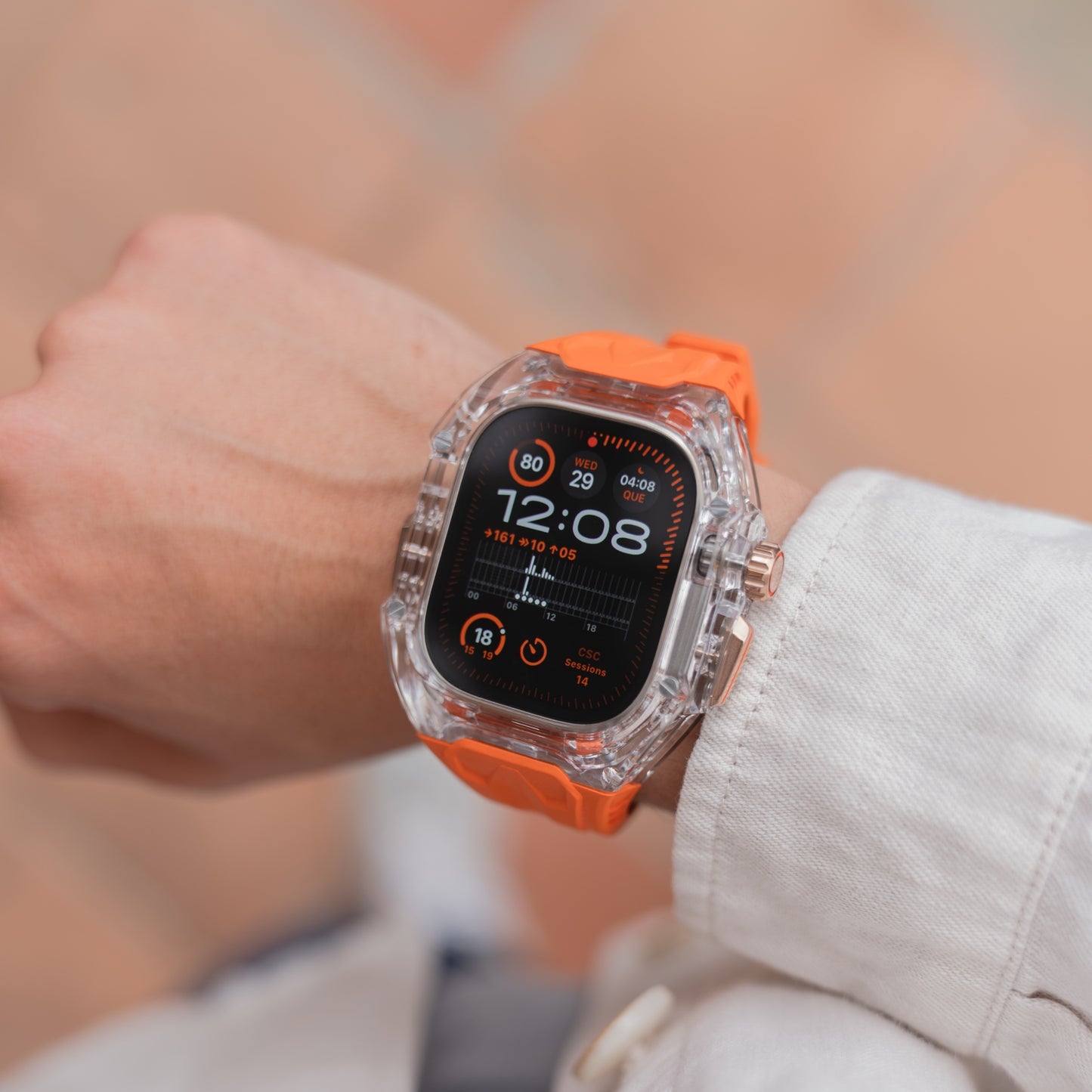 Eine Person trägt ein arktisband Apple Watch Armband "Armor Fusion" in Orange mit einem transparenten Hardcase, das die digitale Anzeige hervorhebt.