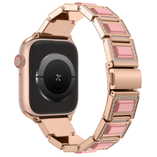 Das arktisband Apple Watch Gliederarmband „Senorita“ verfügt über ein roségoldenes Edelstahlband mit rosa rechteckigen Gliedern, klaren Strasssteinen und passt zu Smartwatches mit quadratischem schwarzen Bildschirm und runder Seitentaste; Apple Watch kompatibel.