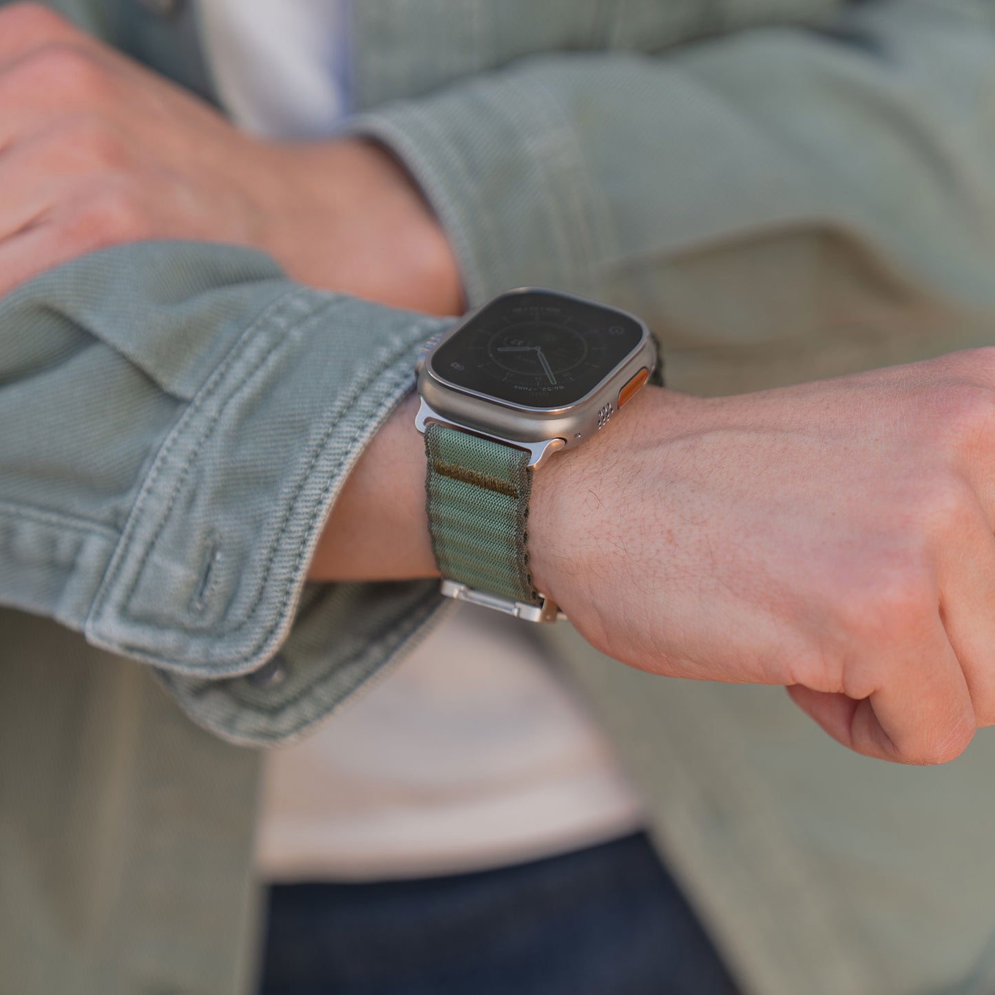 Nahaufnahme einer Person, die das arktisband Apple Watch Armband "CoreX" von arktisband trägt und ihren Jackenärmel anpasst.