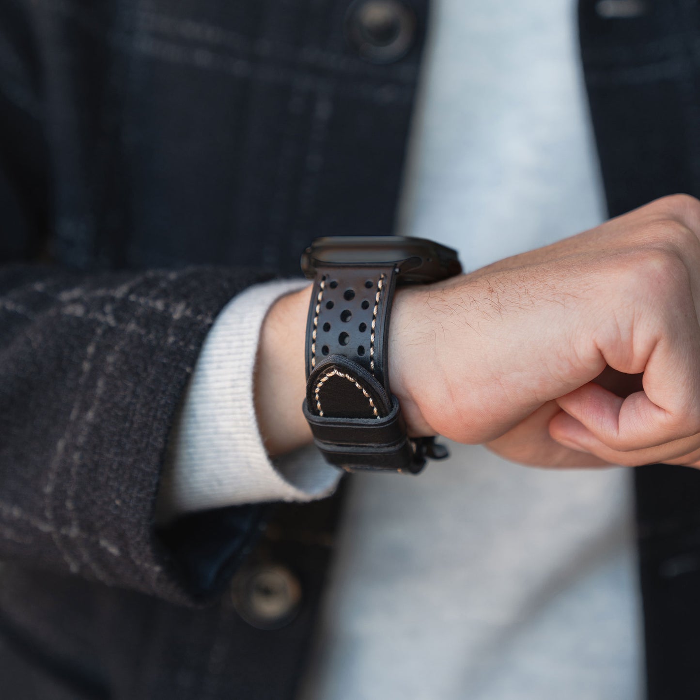 Eine Person trägt eine schwarze Smartwatch mit dem arktisband Apple Watch Lederarmband "Toronto" von arktisband an ihrem Handgelenk.