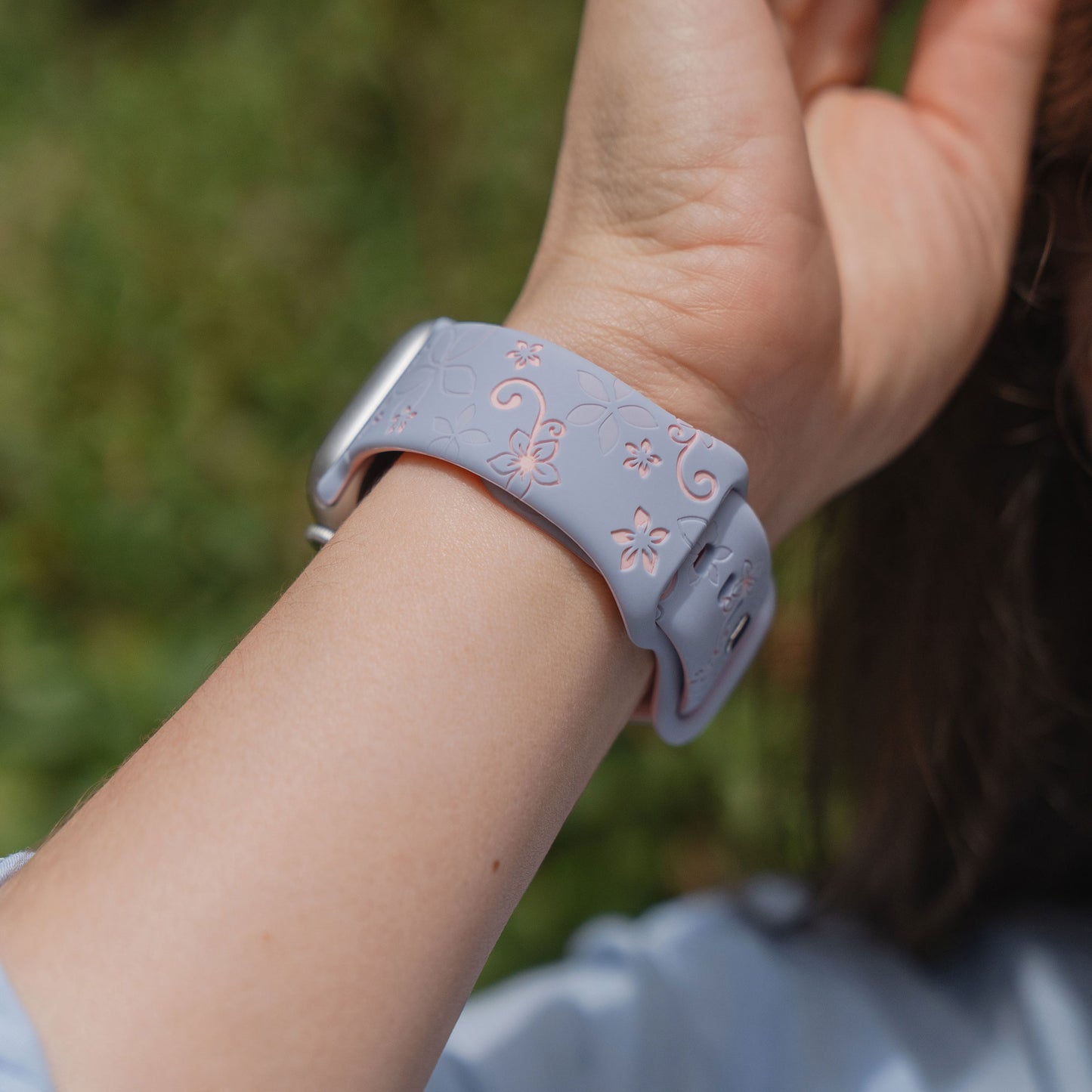 Eine Nahaufnahme eines Handgelenks im Freien, das das arktisband Apple Watch Silikonarmband "Bloom" von arktisband trägt.