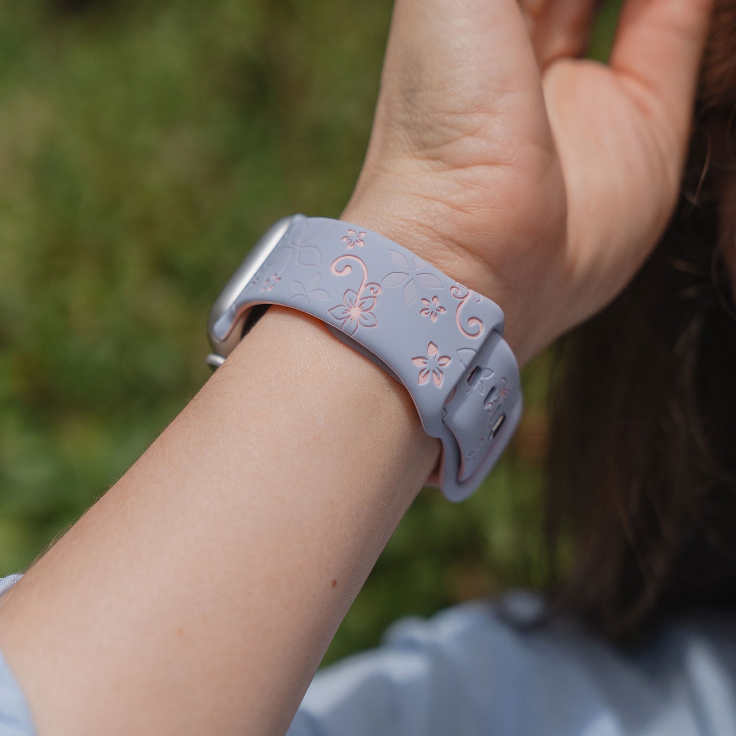 Eine Nahaufnahme eines Handgelenks im Freien, das das arktisband Apple Watch Silikonarmband "Bloom" von arktisband trägt.