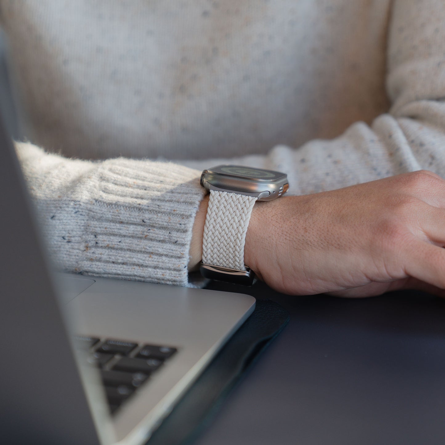 Geflochtenes Armband „Casual“ am Handgelenk beim Tippen am Laptop