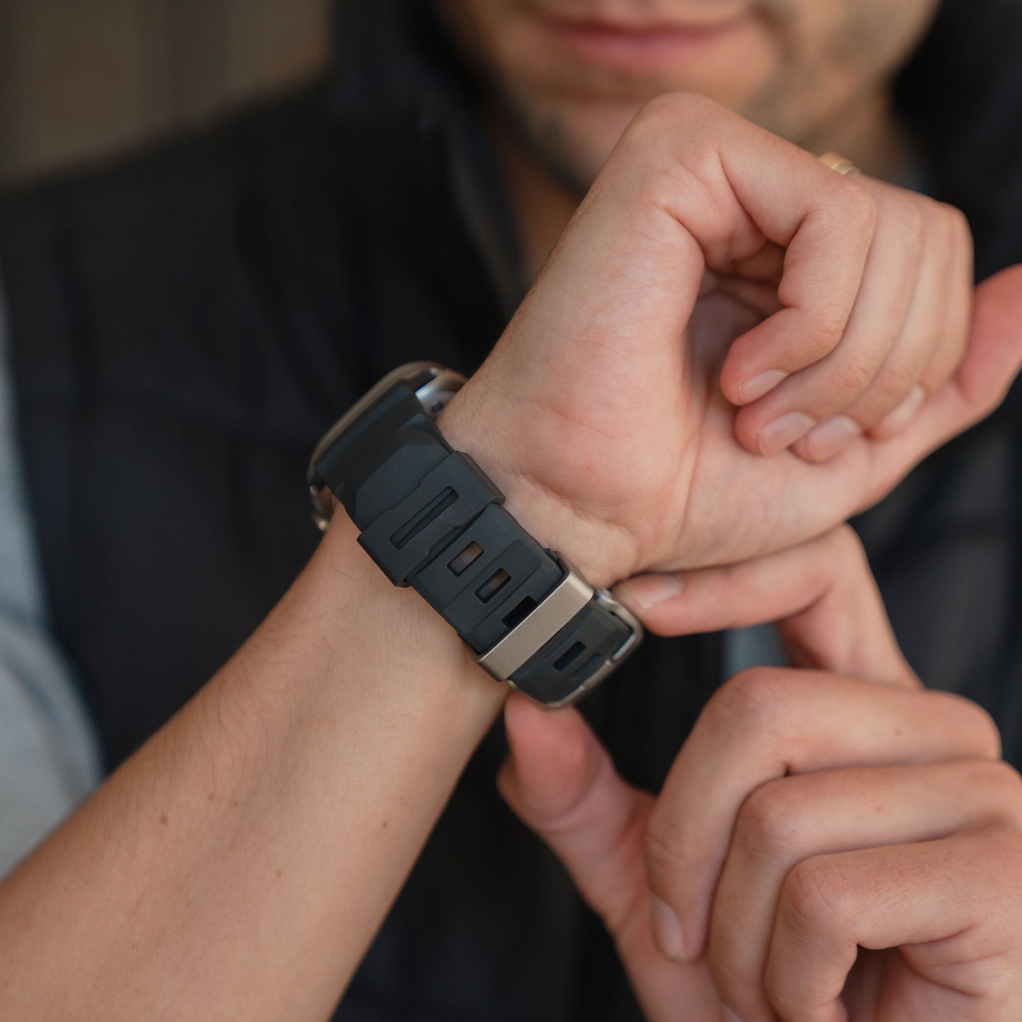 Nahaufnahme einer Person, die das arktisband Apple Watch Armband "Flux" mit einer Edelstahl-Schließe an ihrem Handgelenk befestigt.