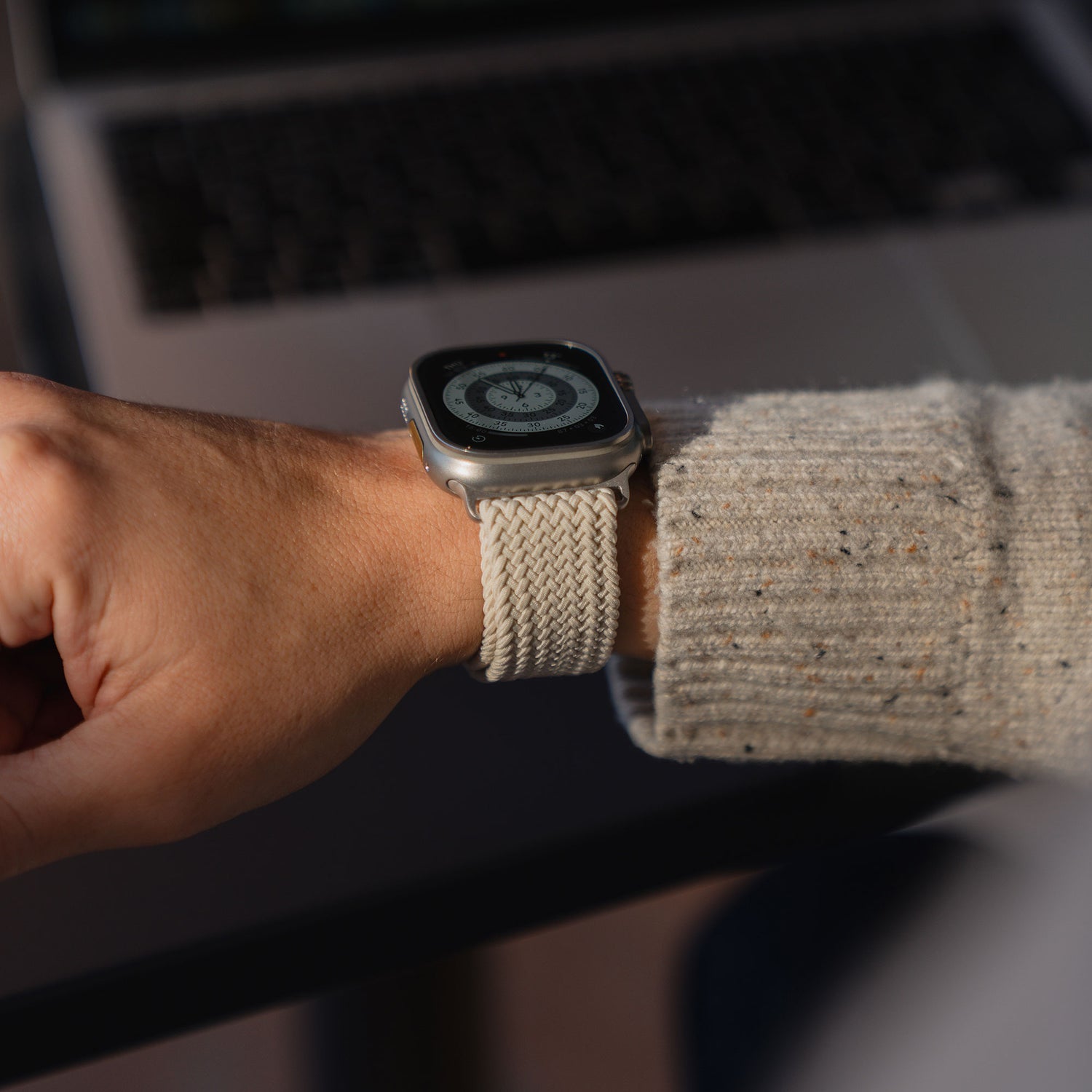 Geflochtenes Armband „Casual“ am Handgelenk vor einem Laptop