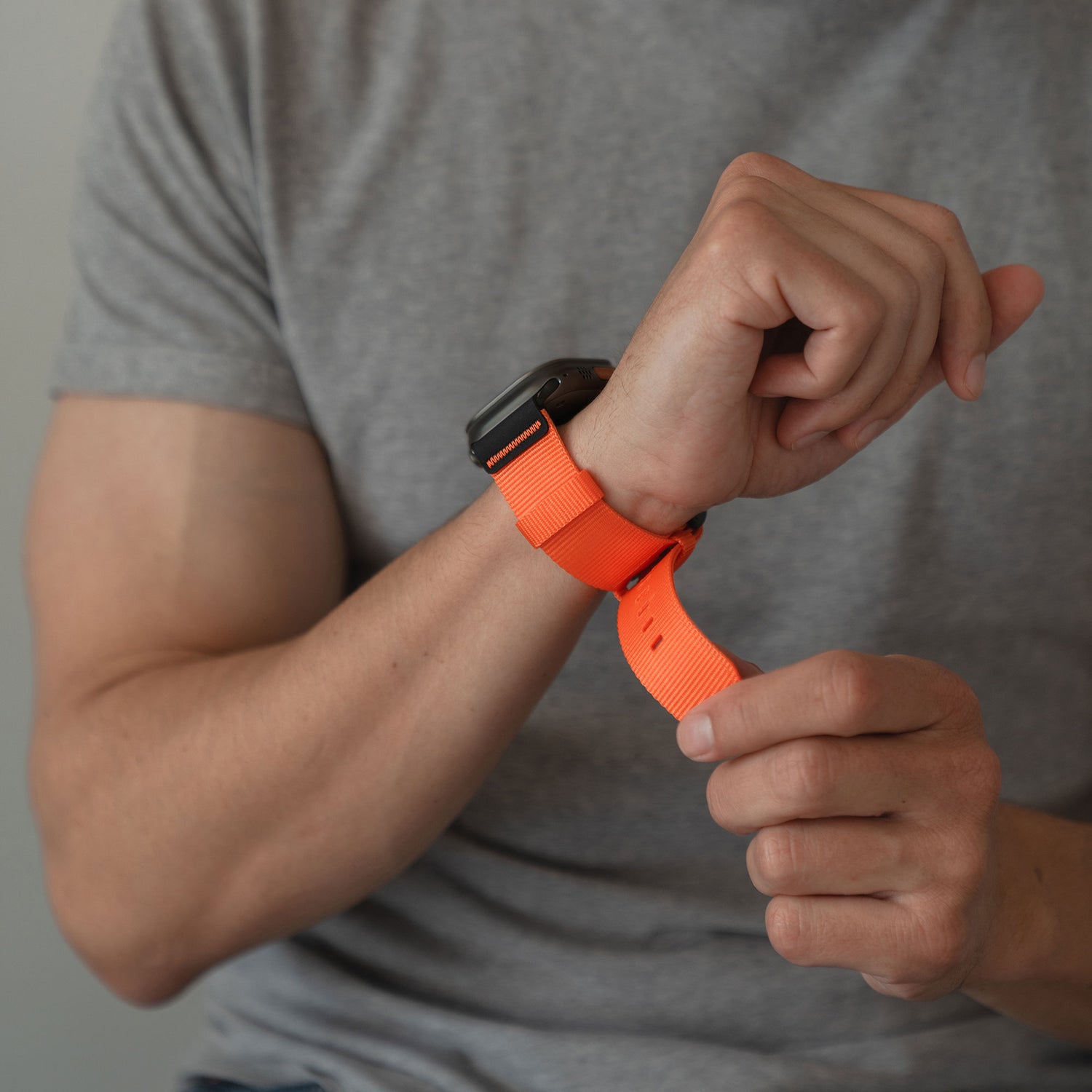 Person mit grauem Hemd, die ein arktisband Apple Watch Armband "Terra" an ihrem Handgelenk anpasst.