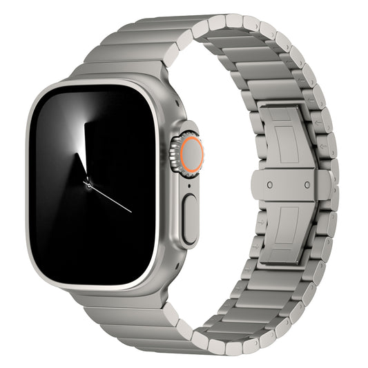 Die arktisband Apple Watch Ultra verfügt über ein silbernes rechteckiges Gehäuse, ein schwarzes analoges Display, eine Metalllünette mit seitlichem Knopf und eine orangefarbene Krone, gepaart mit dem arktisband „Phantom“ Titanarmband mit Metallgliedern.