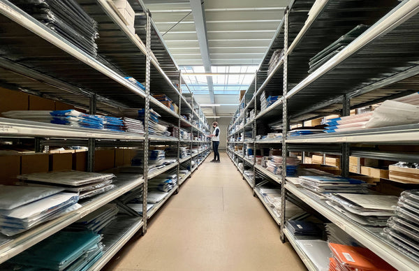 Lange Regalreihe im Arktis Lager mit einer Frau die Ware einsammelt