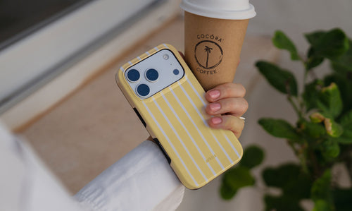 Frau hält gelbe Hülle mit weißen Streifen für das iPhone 17 Pro in ihrer Hand.