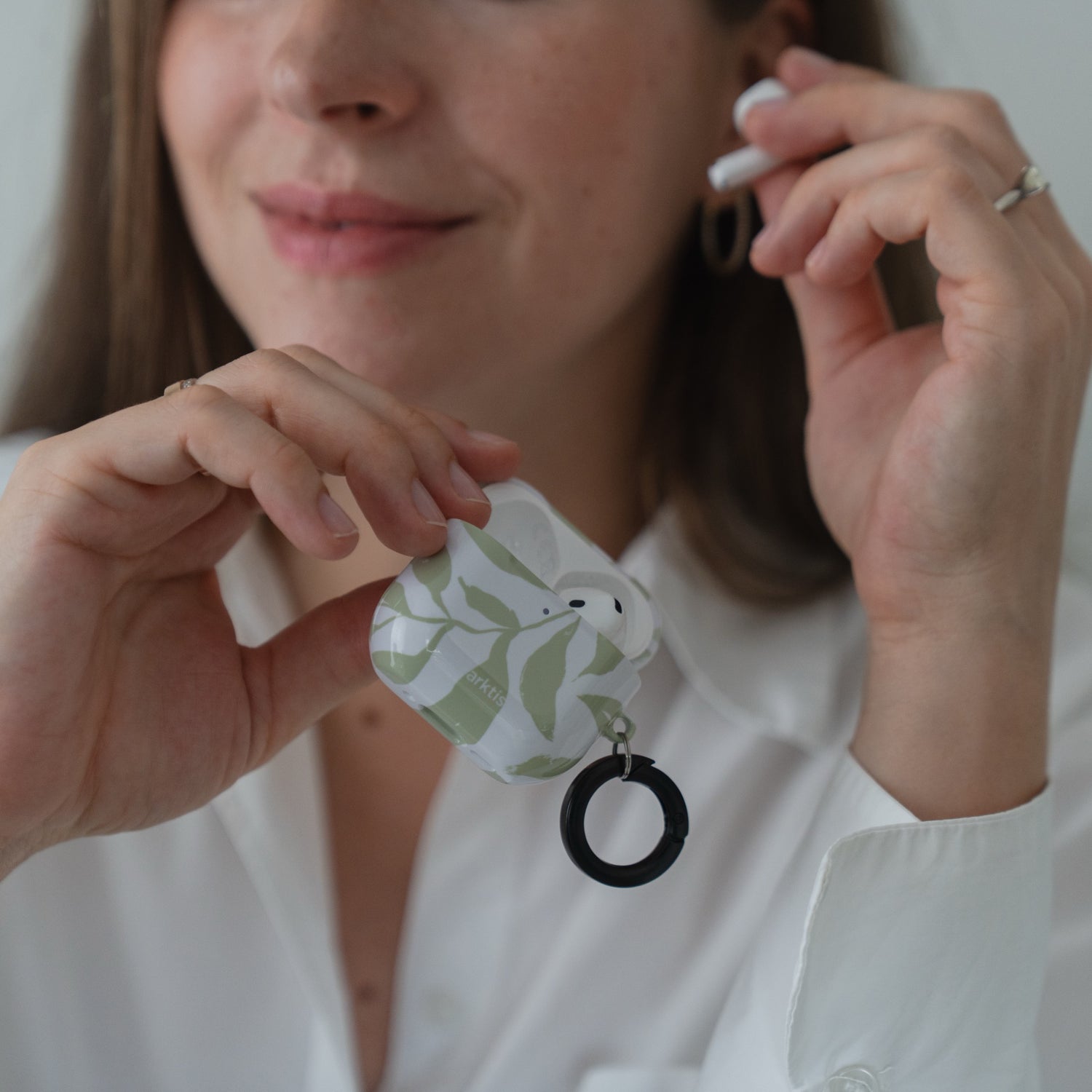 Eine offene arktis AirPods 5-Hülle – Botanic-Ladeetui mit einem grünen Blattmuster im Botanik-Stil und einem schwarzen, kreisförmigen Ring.
