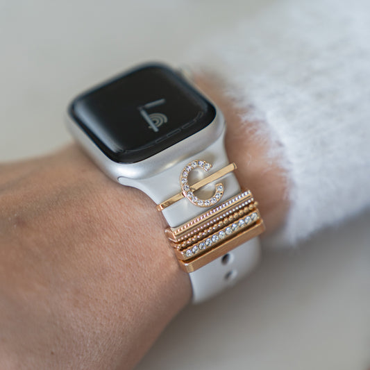 Die arktisband Apple Watch Charms „C Style“ von arktisband – mit goldenen und strassbesetzten Ringen für weiße Smartwatch-Armbänder, einschließlich eines C-förmigen Charms – verleihen Ihrem Look eine schicke, einzigartige Note, ideal für Liebhaber stylischer Armbänder.