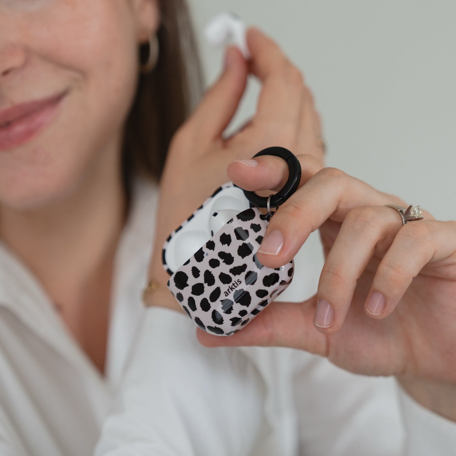 Eine Person hält eine geöffnete Arktis AirPods 5-Hülle – Cheetah – mit einem schwarz-weißen Leopardenmuster in der Hand.