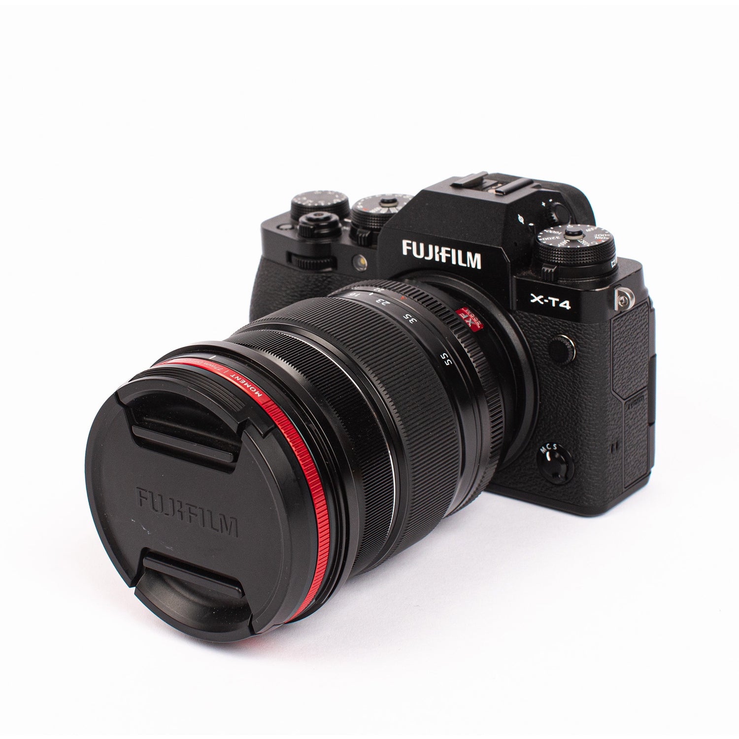 Eine schwarze Fujifilm X-T4 Kamera mit einem großen Objektiv ist mit einem MOMENT 67mm CineBloom Diffusionsfilter ausgestattet, um einen weichen Effekt zu erzielen, und steht vor einem weißen Hintergrund.