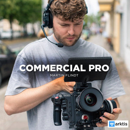 Ein Mann mit Headset nutzt die Commercial Pro-Videokamera auf einem Bürgersteig und stellt damit seine filmischen Fähigkeiten unter Beweis. Der Text lautet „COMMERCIAL PRO Martin Flindt“ mit dem arktis.de-Logo in der unteren rechten Ecke.