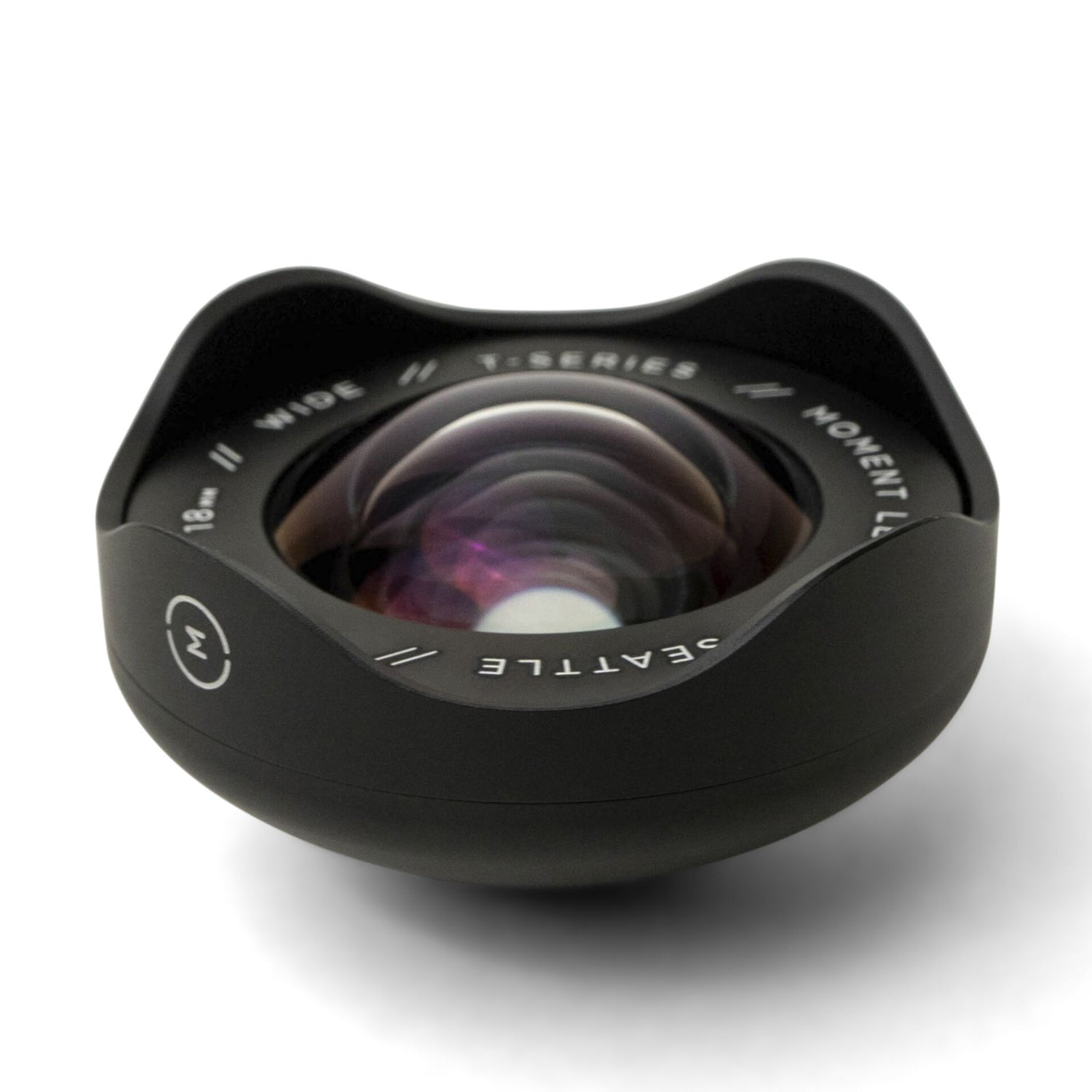 Das MOMENT 18-mm-Weitwinkelobjektiv - T-Serie verfügt über ein gebogenes Glaselement und ein schwarzes Gehäuse, perfektes iPhone Kamera Zubehör für die Aufnahme weitläufiger Szenen. Beschriftet mit Moment und Seattle.
