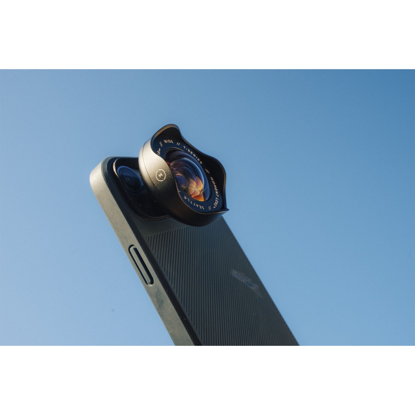 Ein iPhone mit dem MOMENT 18mm Weitwinkelobjektiv - T-Serie wird zum Top-iPhone Kamera Zubehör, wie hier unter einem klaren blauen Himmel.