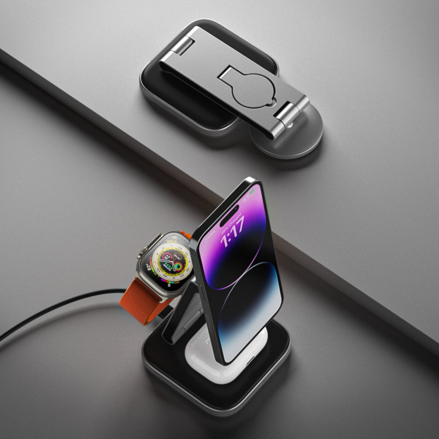 Der Satechi 3-in-1 Foldable Qi2 Wireless Charging Stand von Satechi lädt Ihr Smartphone, Ihre Smartwatch und Ihre Ohrstöpsel zusammen auf einer glatten grauen Oberfläche auf.