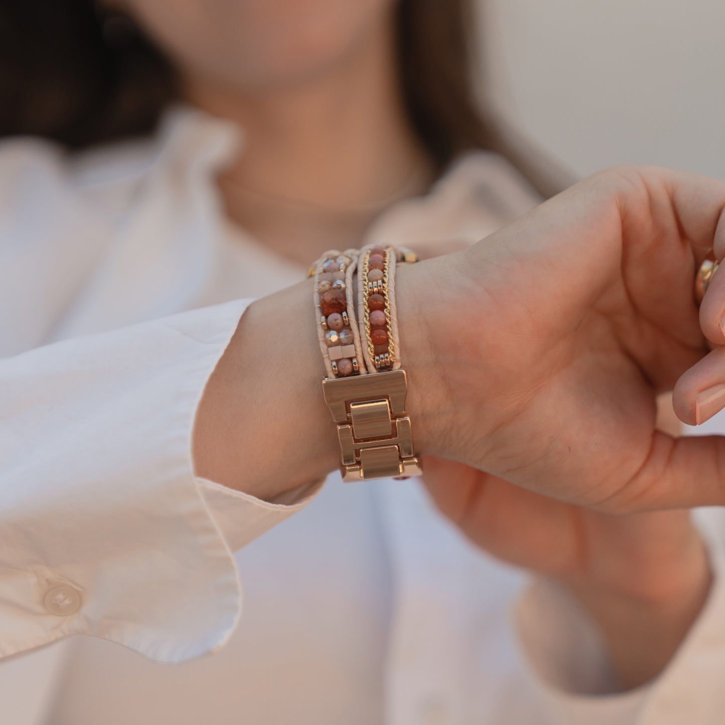 Eine Person in einem weißen Hemd präsentiert das Apple Watch-Armband „Sunset Spirit“ von arktisband an ihrem Handgelenk.