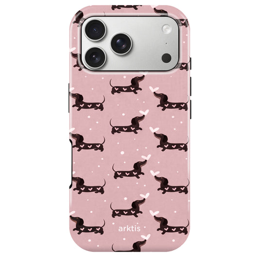 Die arktis iPhone 17 Pro Hülle - Dackel Love zeigt ein pinkes Design mit Dackel, weißen Herzen und Punkten. Hergestellt aus stoßabsorbierendem TPU-Silikon, MagSafe kompatibel und mit dem Schriftzug "arktis" auf der Unterseite.
